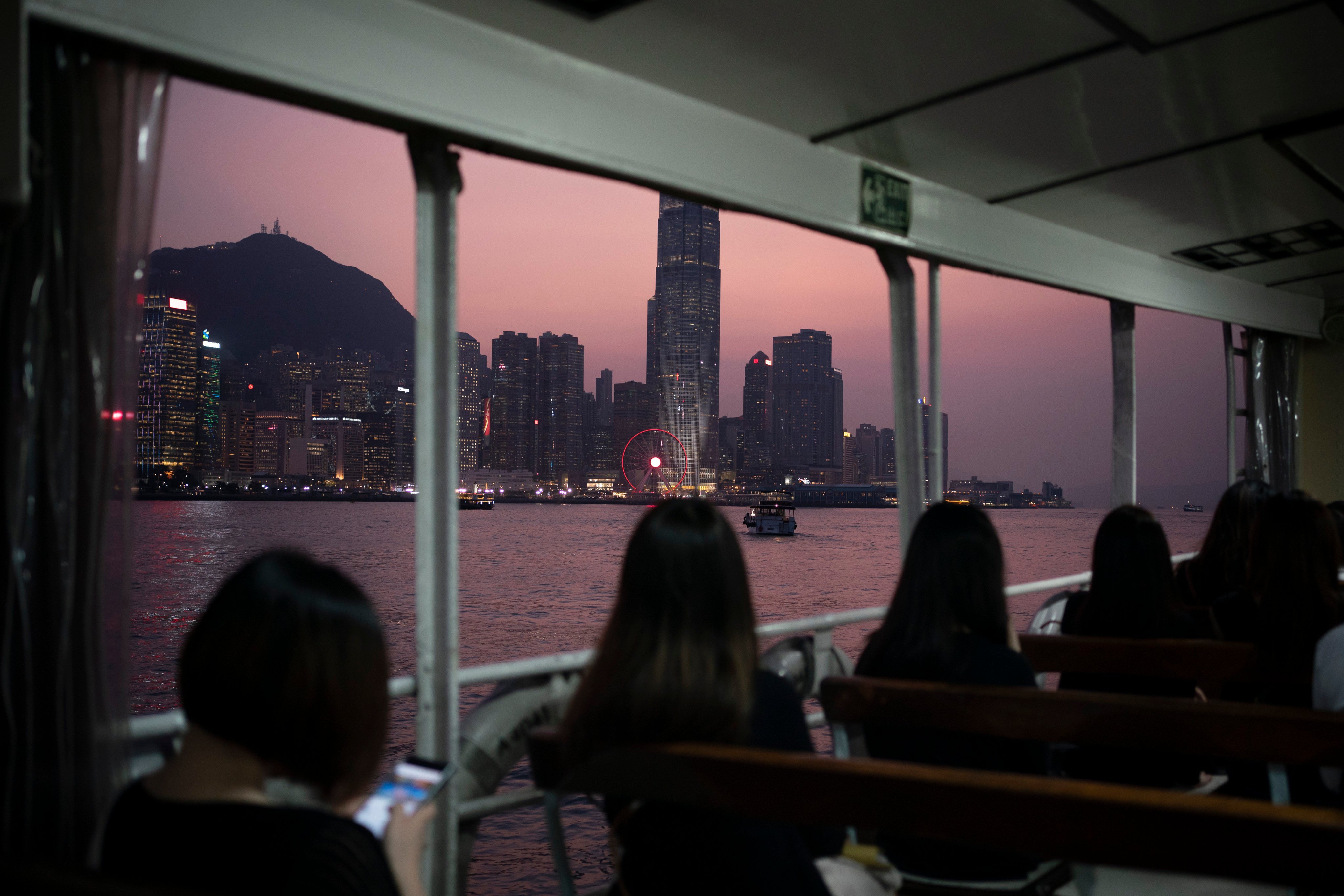 People ride on a ferry from Hong Kong Island to Kowloon as the sun sets, in 2019. Photo: AP