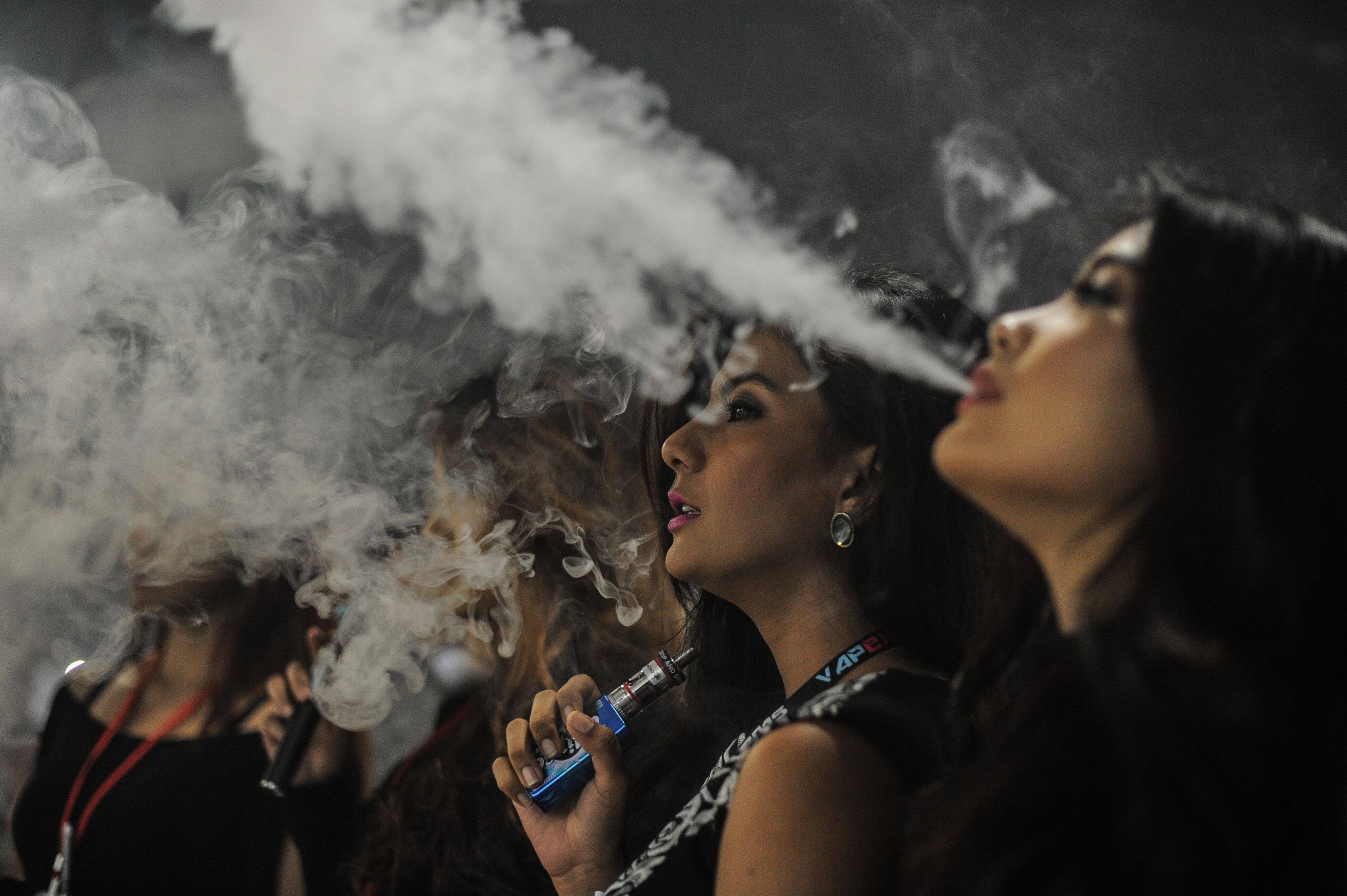 People smoking electronic cigarettes during the Vape Fair in Kuala Lumpur in December 2015. Photo: AFP