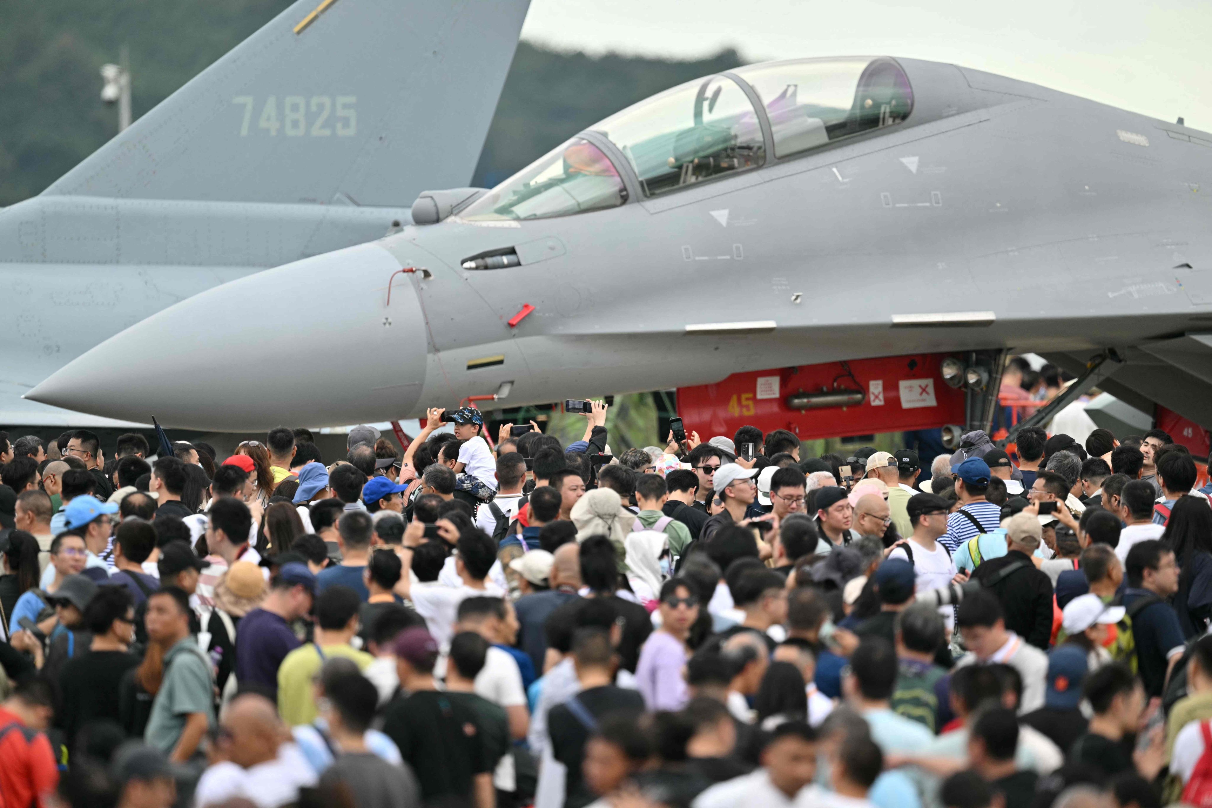 Visitors are seen near the Shenyang J-16 fighter jet at the Zhuhai air show in Guangdong province on Friday. Photo: AFP