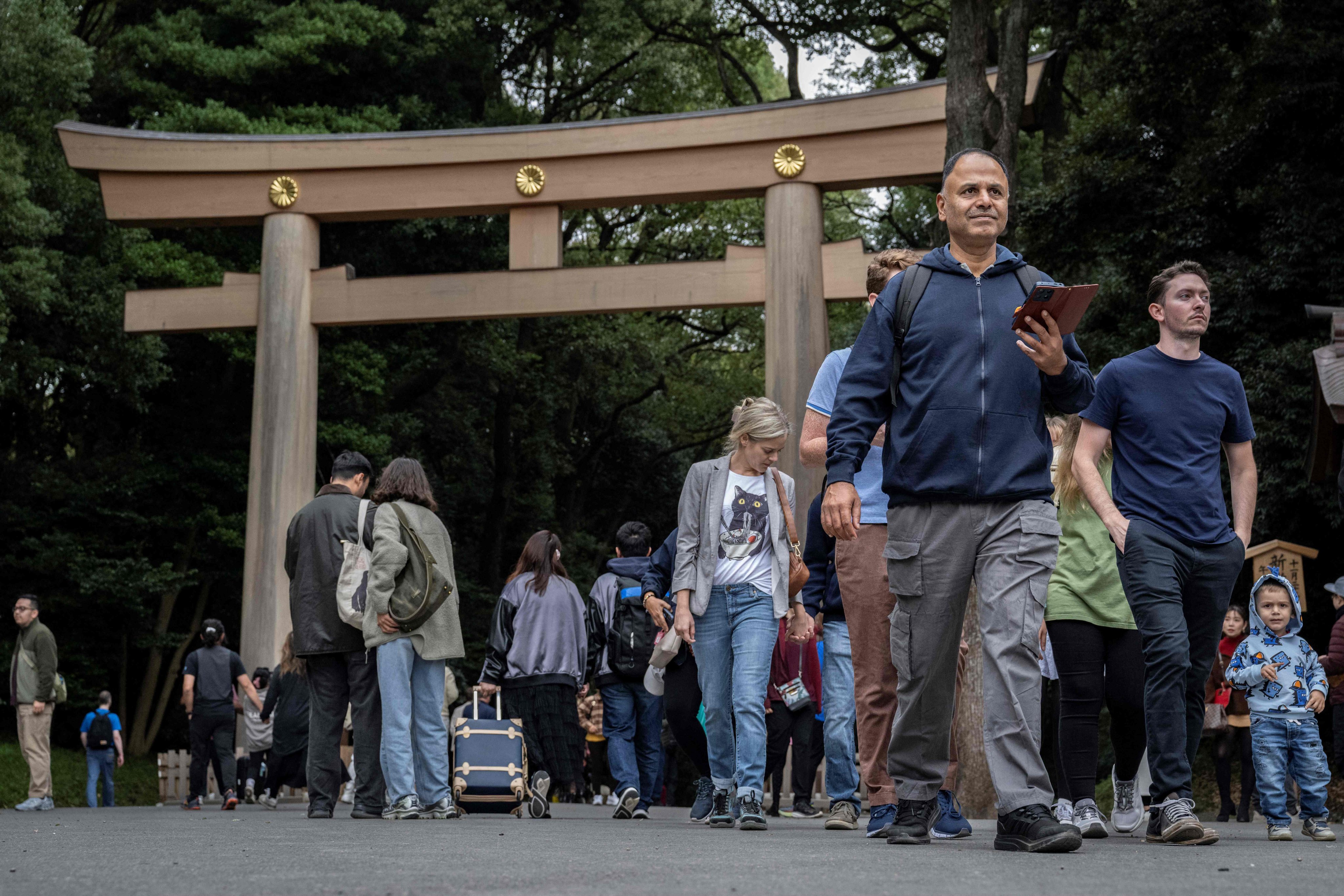 People walk past a torii gate at Meiji shrine in Tokyo. An American tourist was arrested for etching letters into a traditional wooden gate at a Tokyo shrine. Photo: AFP