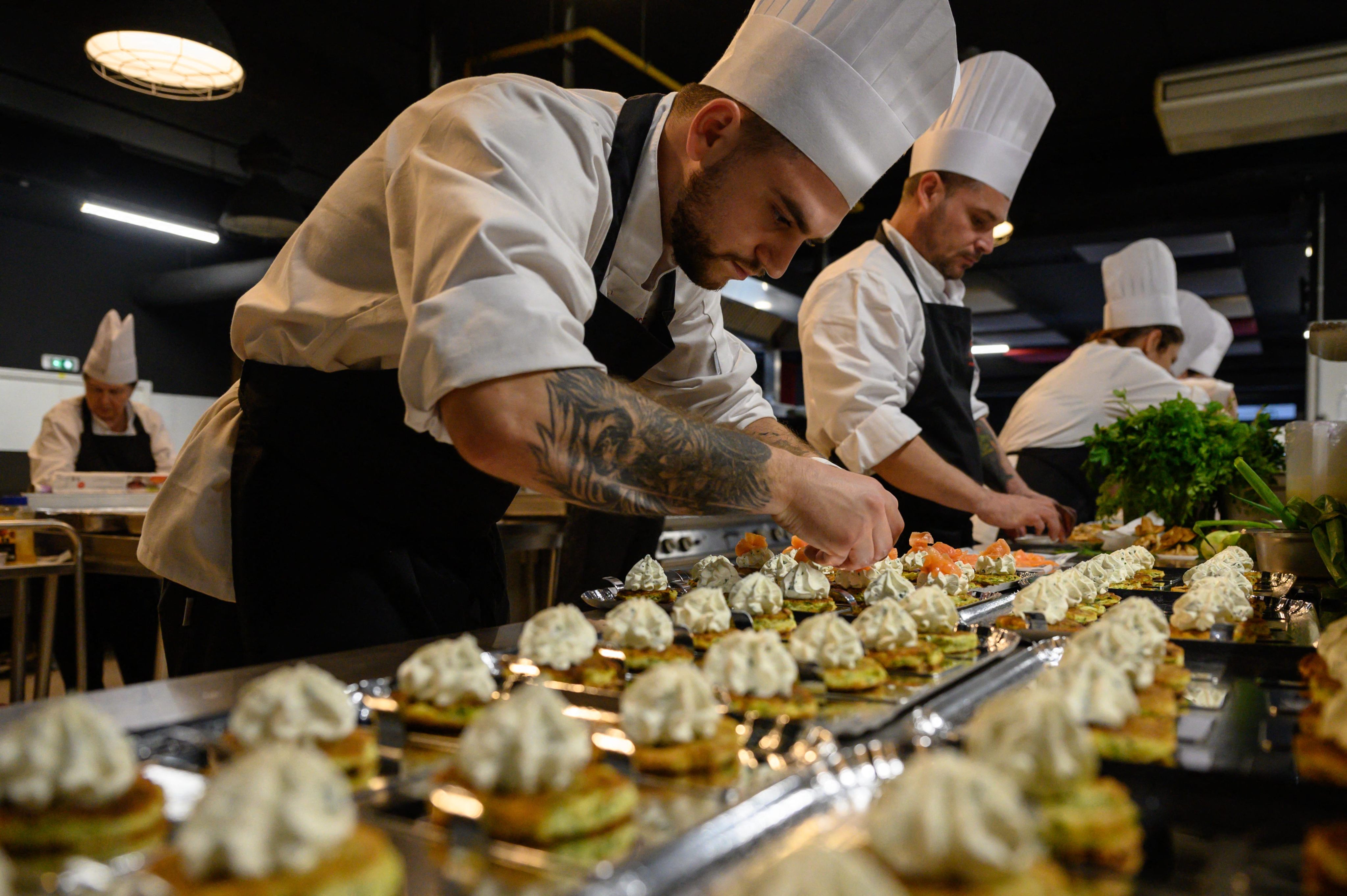 Vitalii Aheiev (front) prepares food at an event in Toulouse, France. A training school in the city offers hope to Ukrainians who are looking forward to the day that the war with Russia ends. Photo: AFP