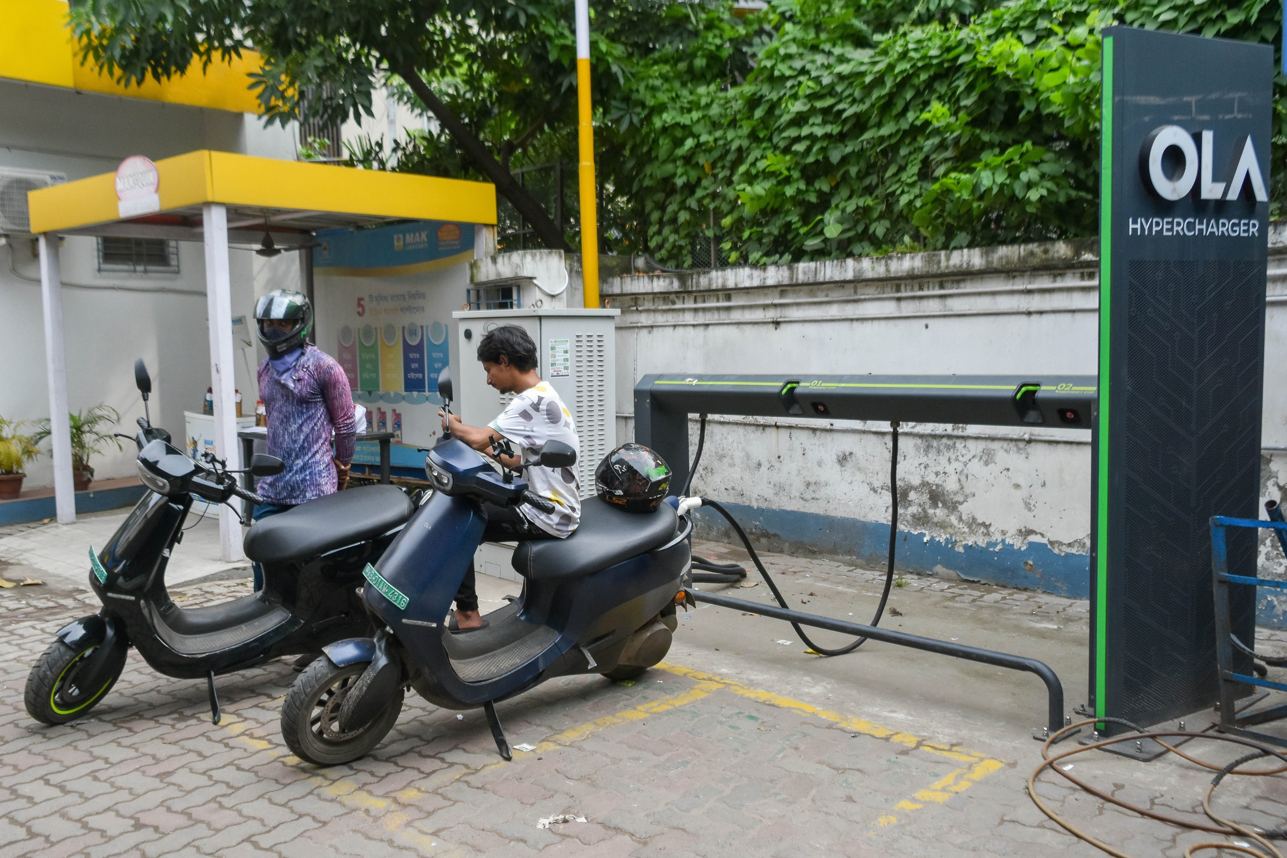 People charge their electric scooters at a charging station in Kolkata, India. Photo: NurPhoto via Getty Images