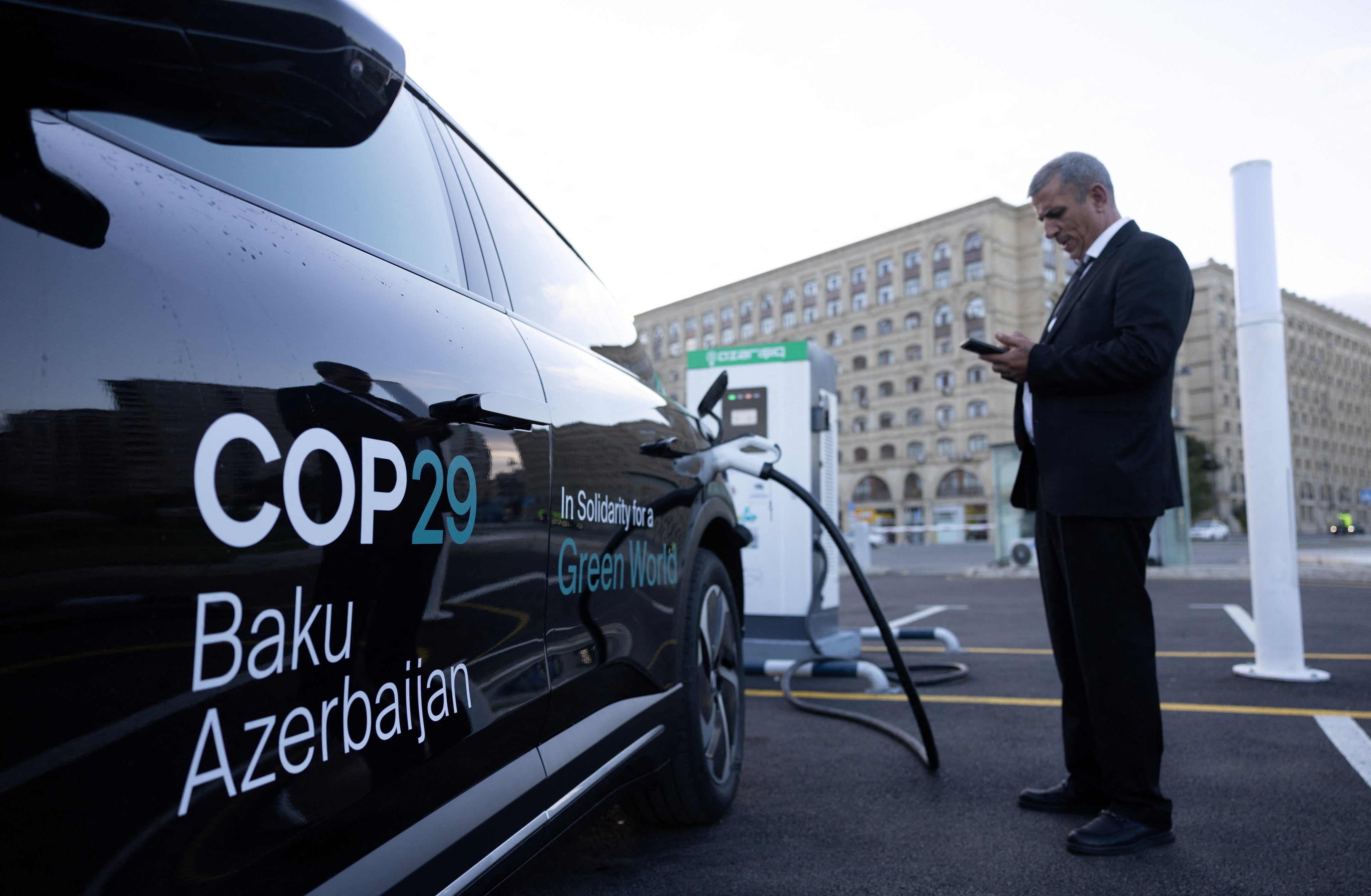 A driver uses his mobile phone at the electric charging station as Baku city hosts the United Nations Climate Change Conference (Cop29), in Azerbaijan, on November 14. Photo: Reuters 