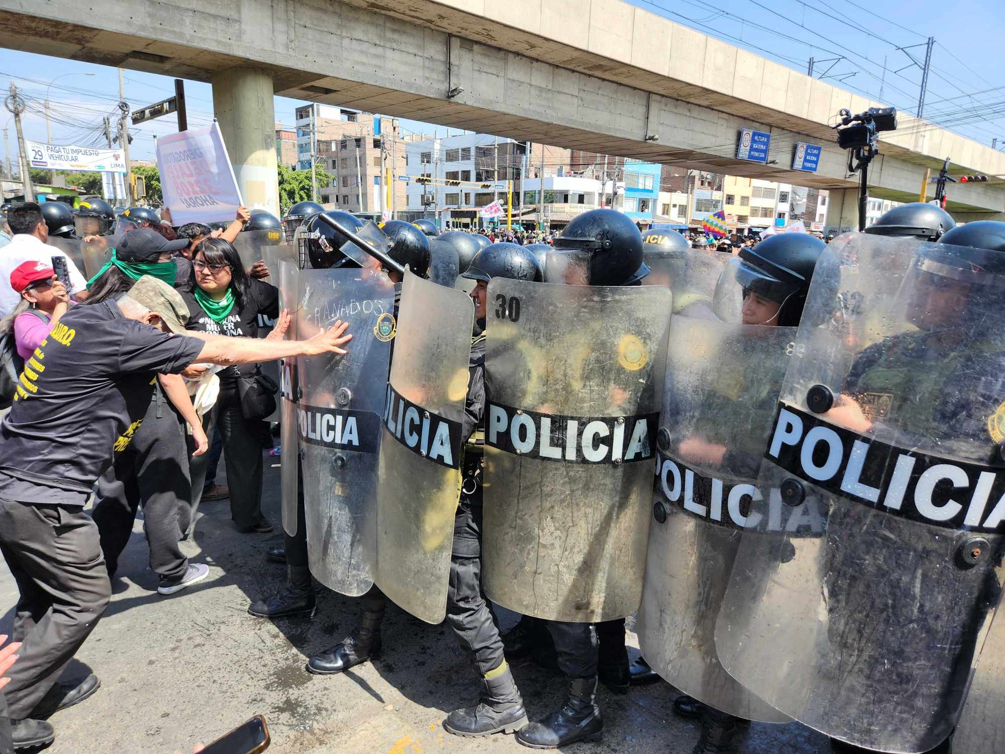 Police in Peru form a shield wall as they encounter people protesting the Apec gathering in Lima. Photo: SCMP