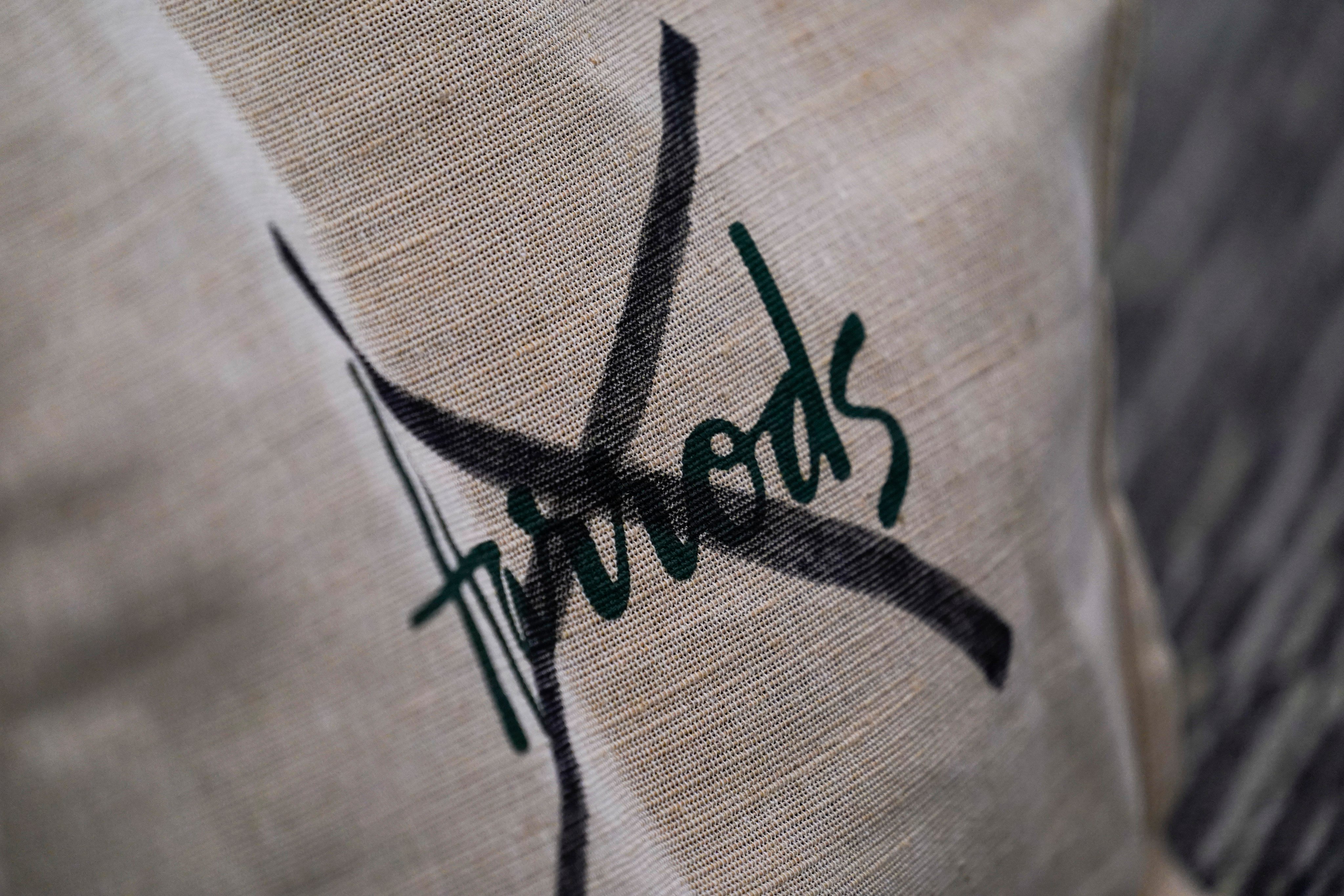 A Harrods tote bag with the brand name crossed out is seen at a press conference in London in October. Photo: AP