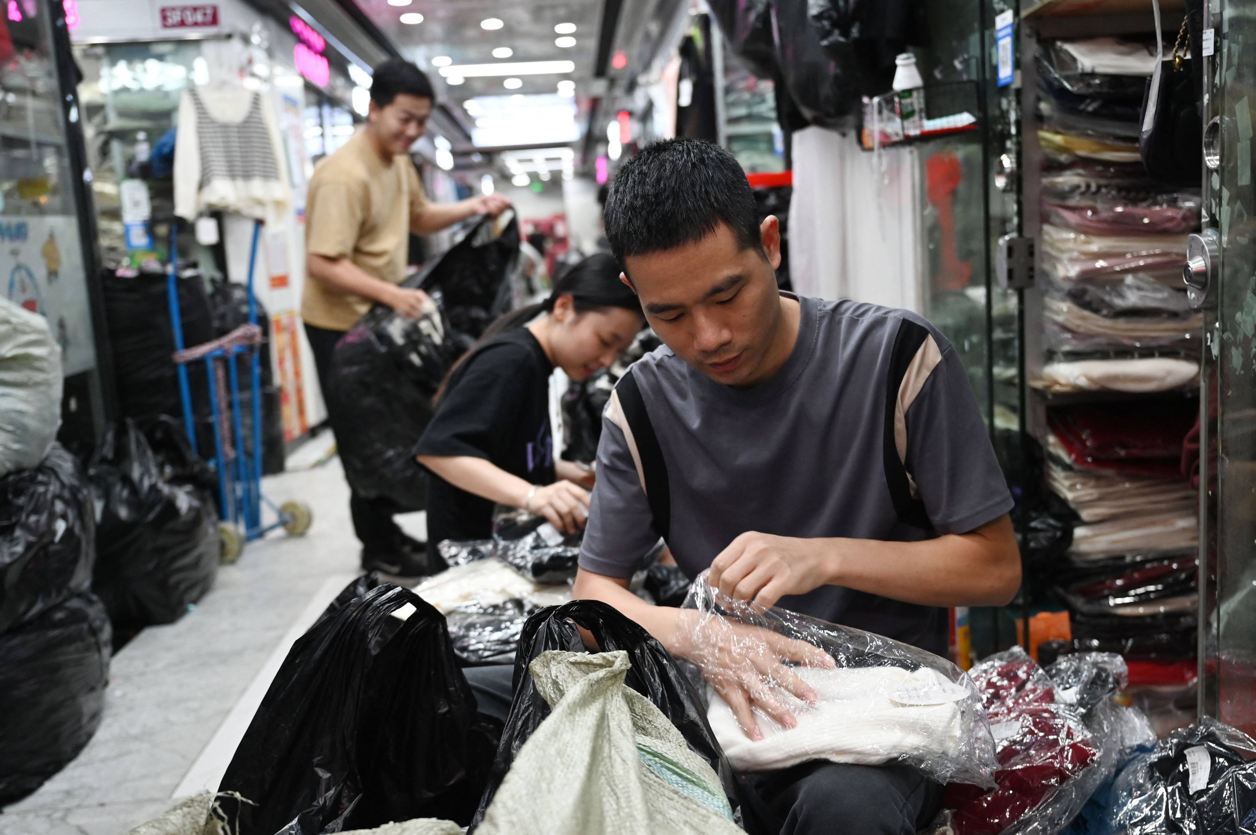 Vendors unpack clothes at a wholesale market in Guangzhou. Photo: AFP