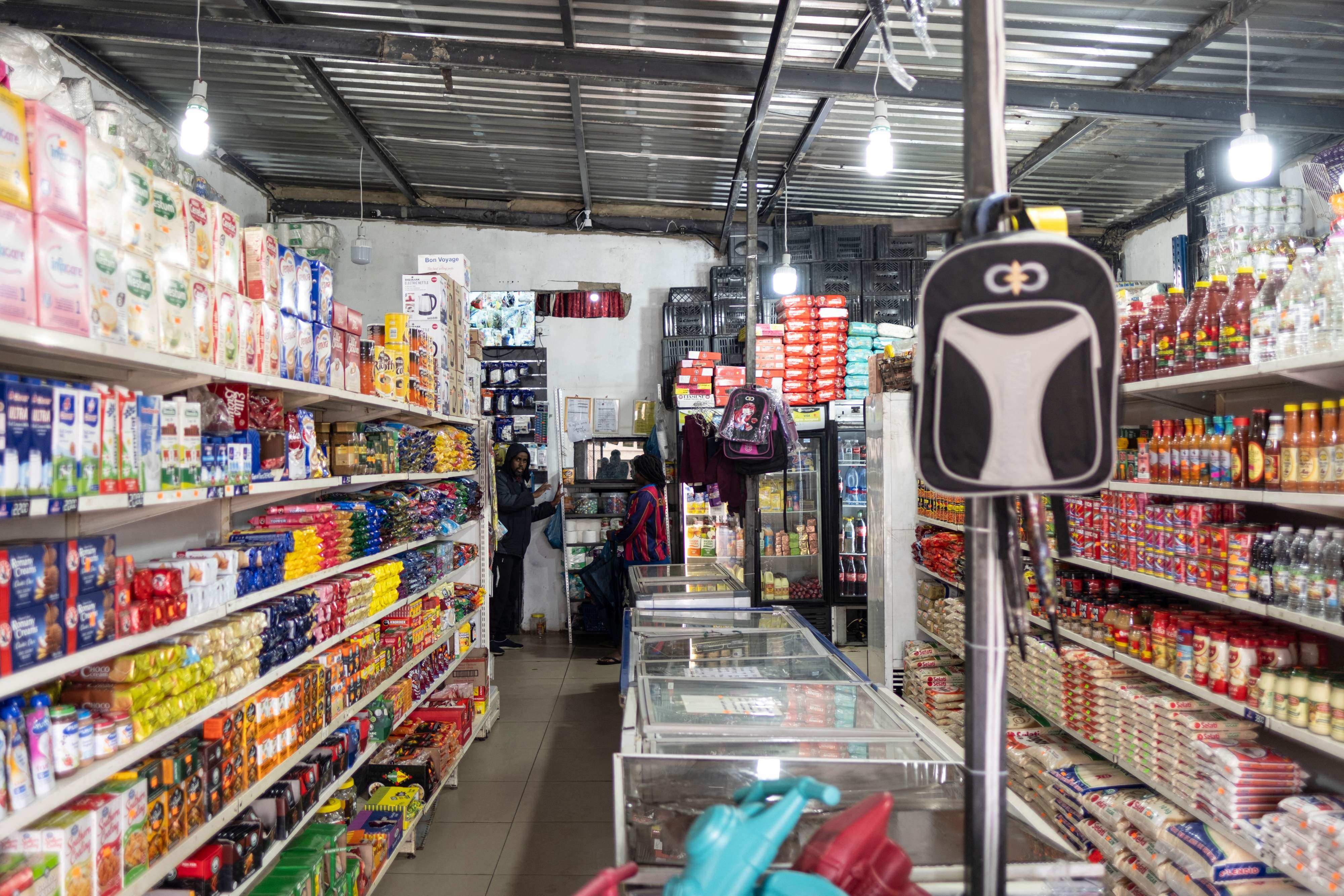 A worker speaks with a customer at a spaza shop in Soweto, South Africa, on November 12. Photo: AFP