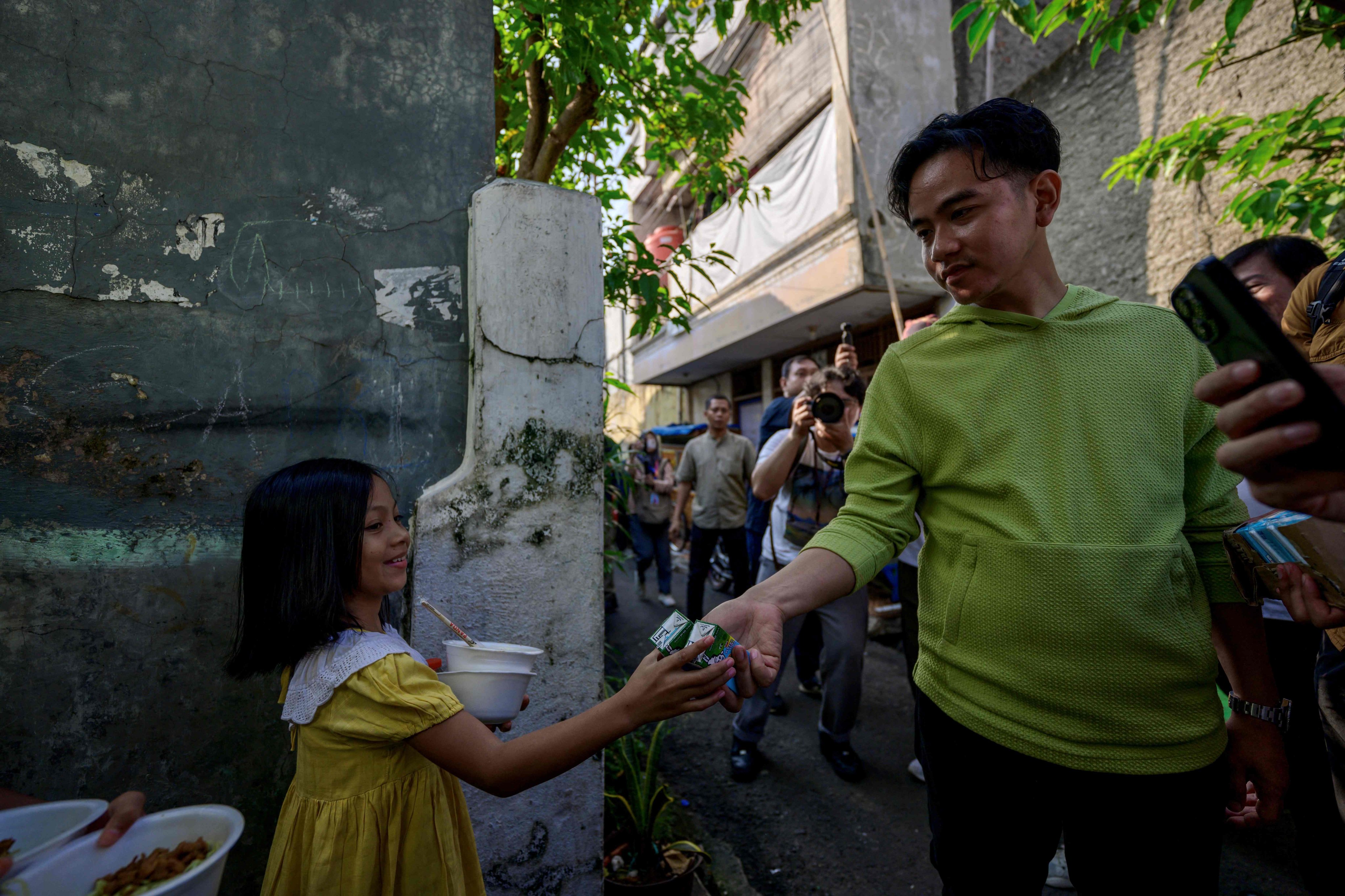 Gibran Rakabuming Raka conducts an impromptu visit to meet residents and children while distributing books and milk in Jakarta in July. Photo: AFP