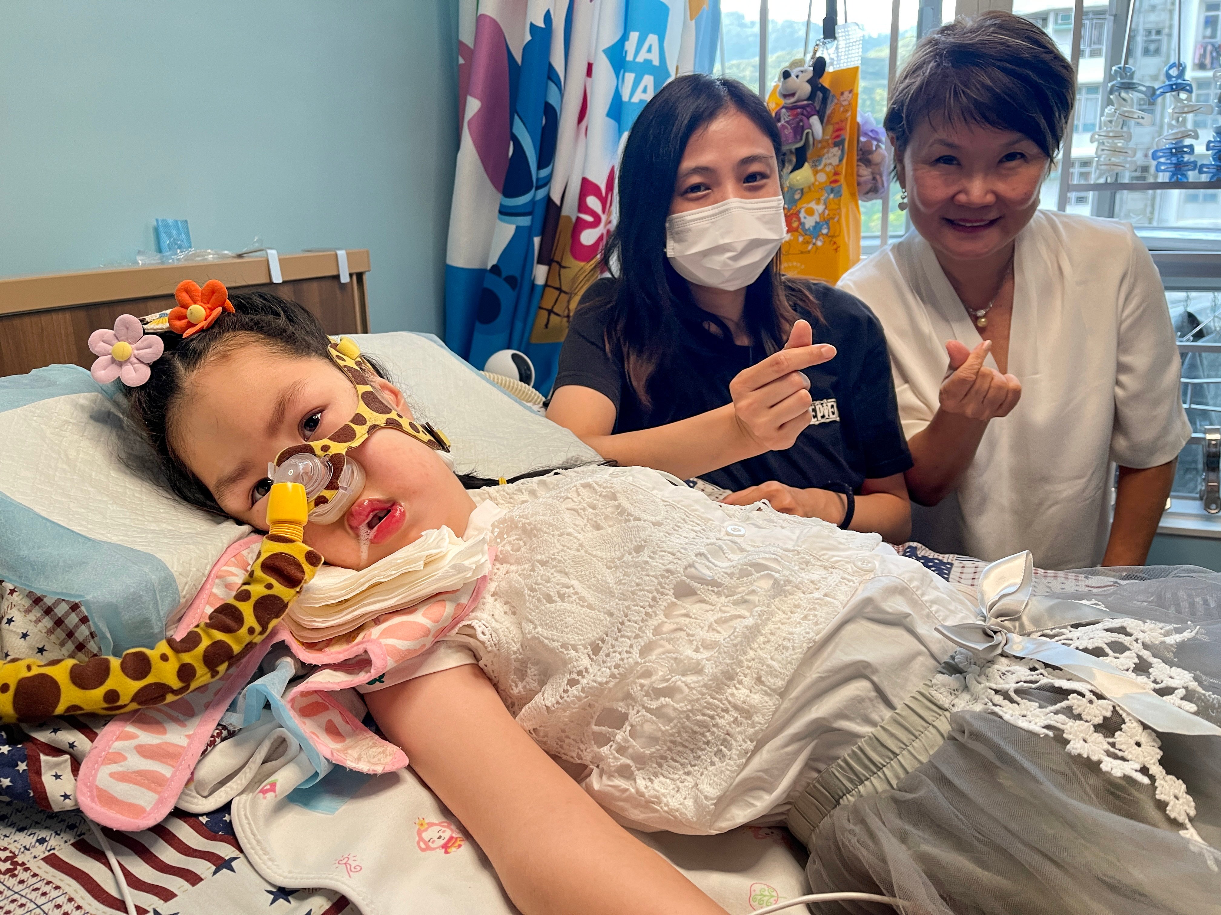 Cheuk Ka, a child with spinal muscular atrophy, is joined by her mother (centre) and Families of SMA Foundation founder Fok Mei-ling. Photo: Cindy Sui