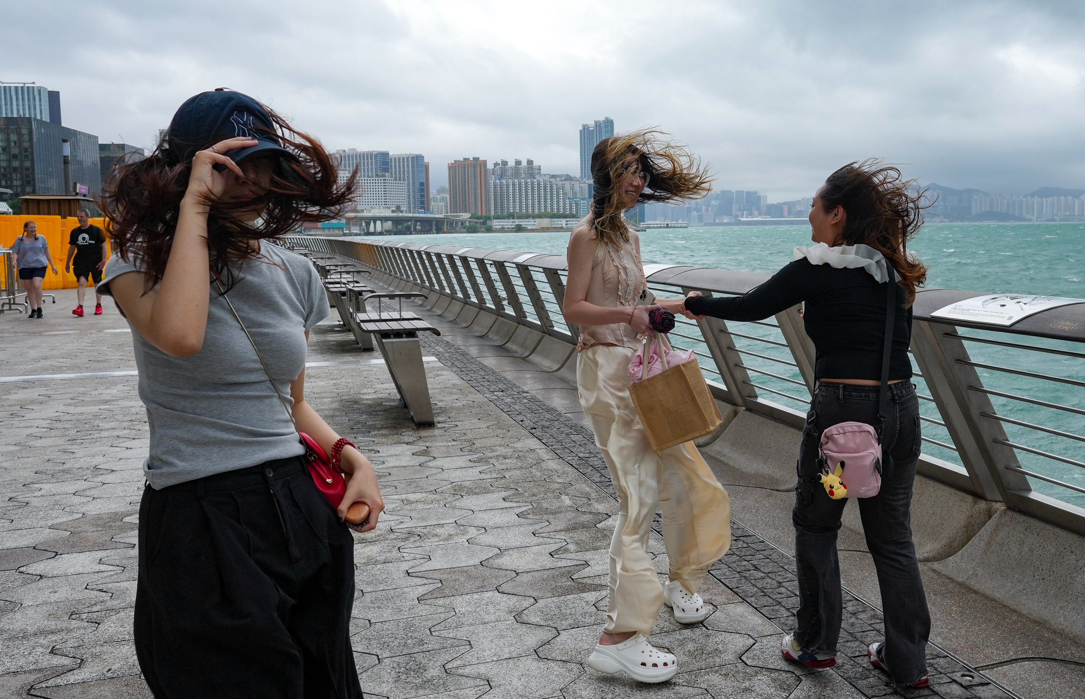 Tourists take pictures in Tsim Sha Tsui while the number 8 warning signal was in effect last week. Photo: May Tse