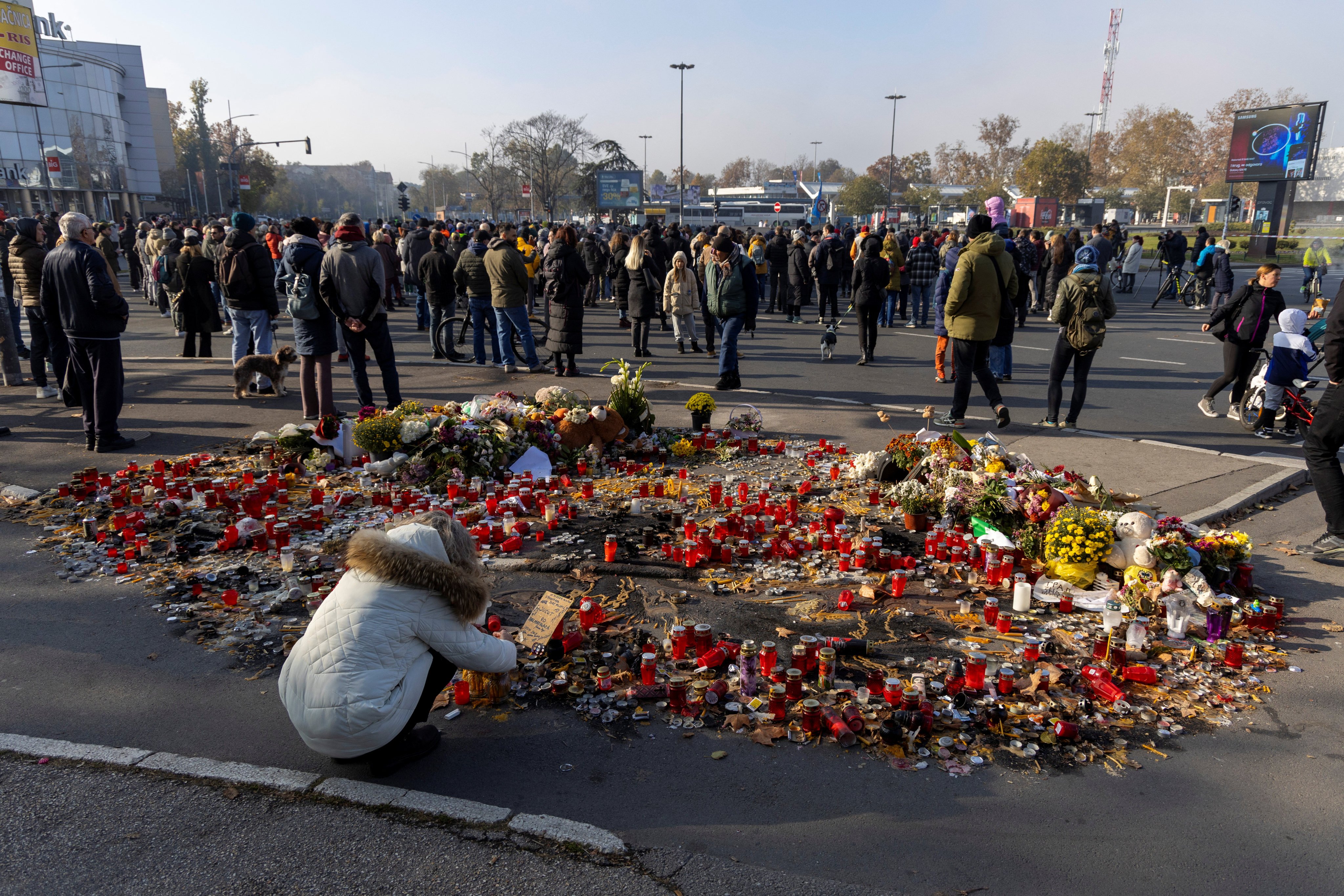 A woman lights candles during a protest over the fatal collapse of a roof at a train station in Novi Sad, Serbia on Sunday. Photo: Reuters