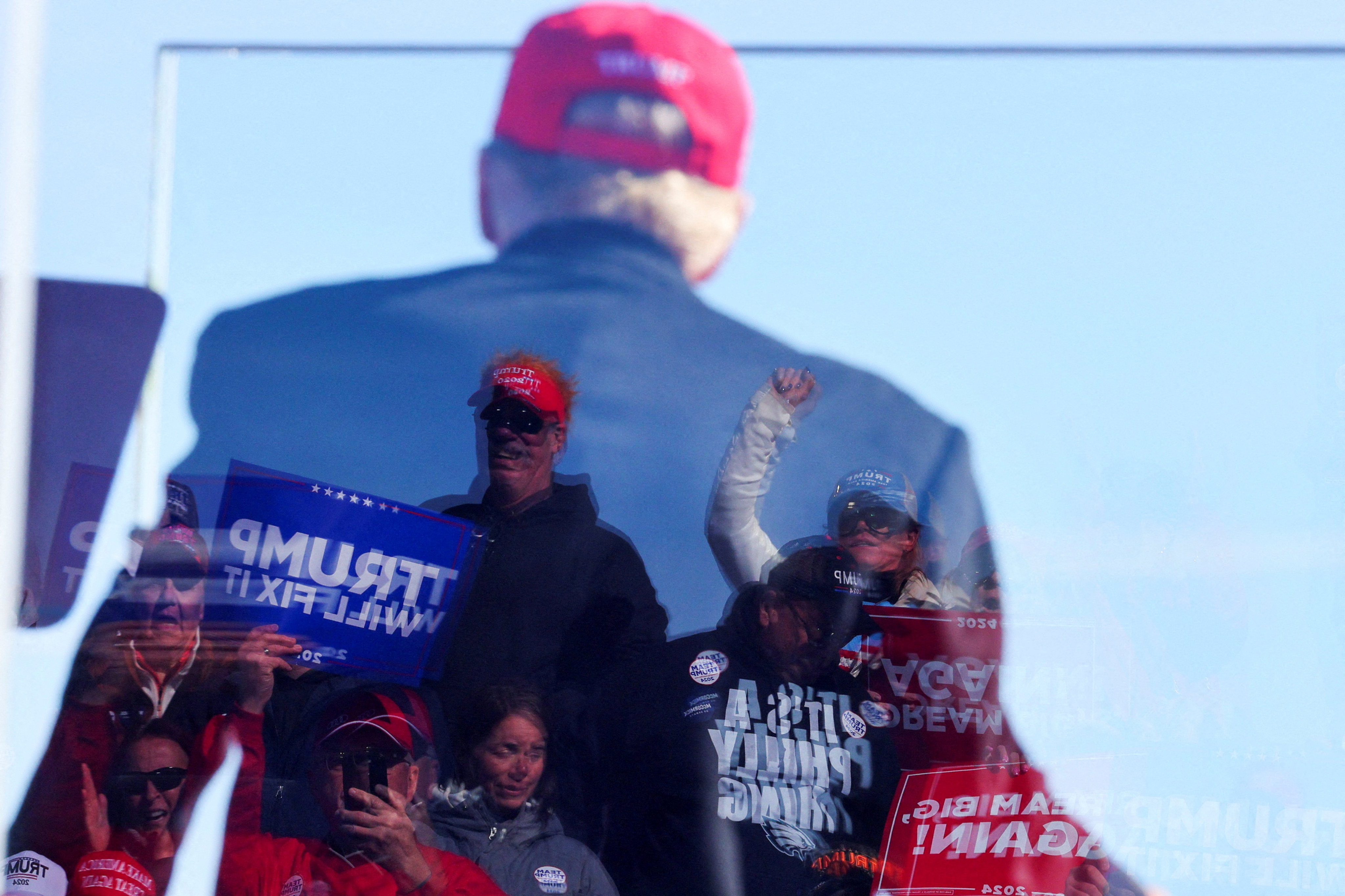 Supporters are reflected in the protective glass as  
Donald Trump holds a rally in Lititz, Pennsylvania, on November 3. Photo: Reuters  