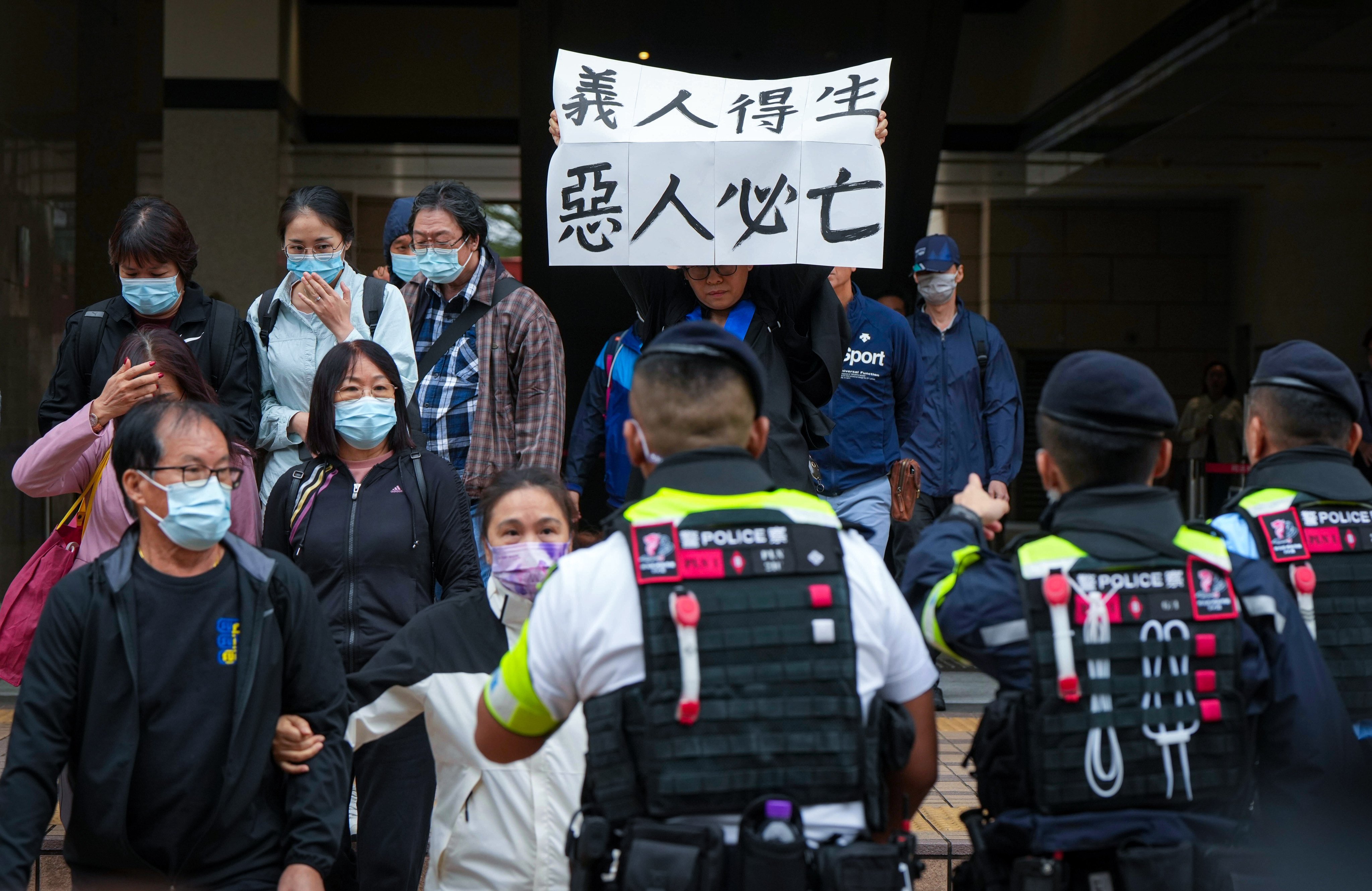 A supporter of one of the defendants, social worker Hendrick Lui, holds up a protest sign outside West Kowloon Court in Cheung Sha Wan before the sentencing hearing. Photo: Sam Tsang