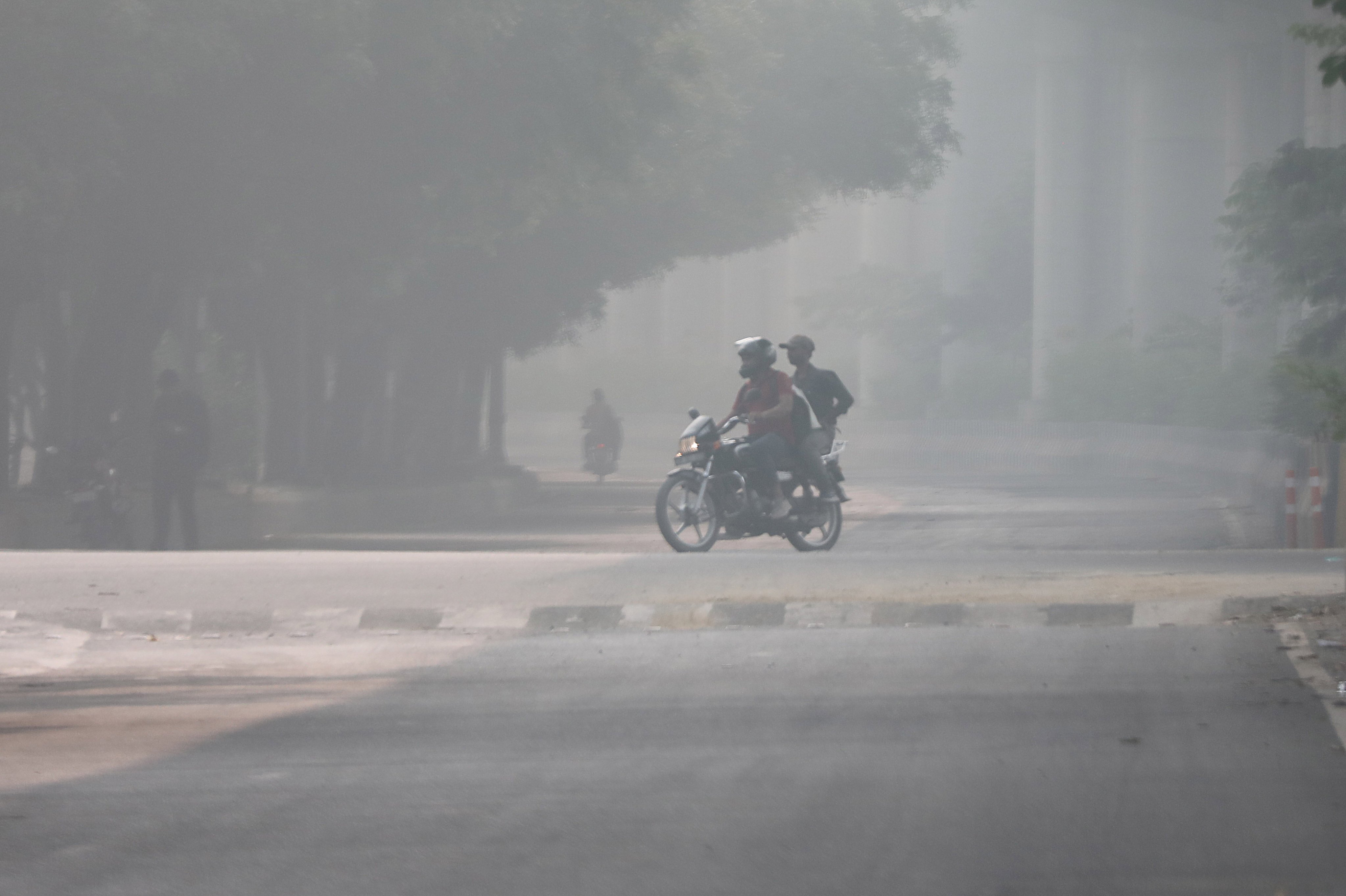 People drive amid heavy smog near New Delhi, India, this month. Pollution levels in the Indian capital have soared way above WHO recommended limits. Photo: EPA