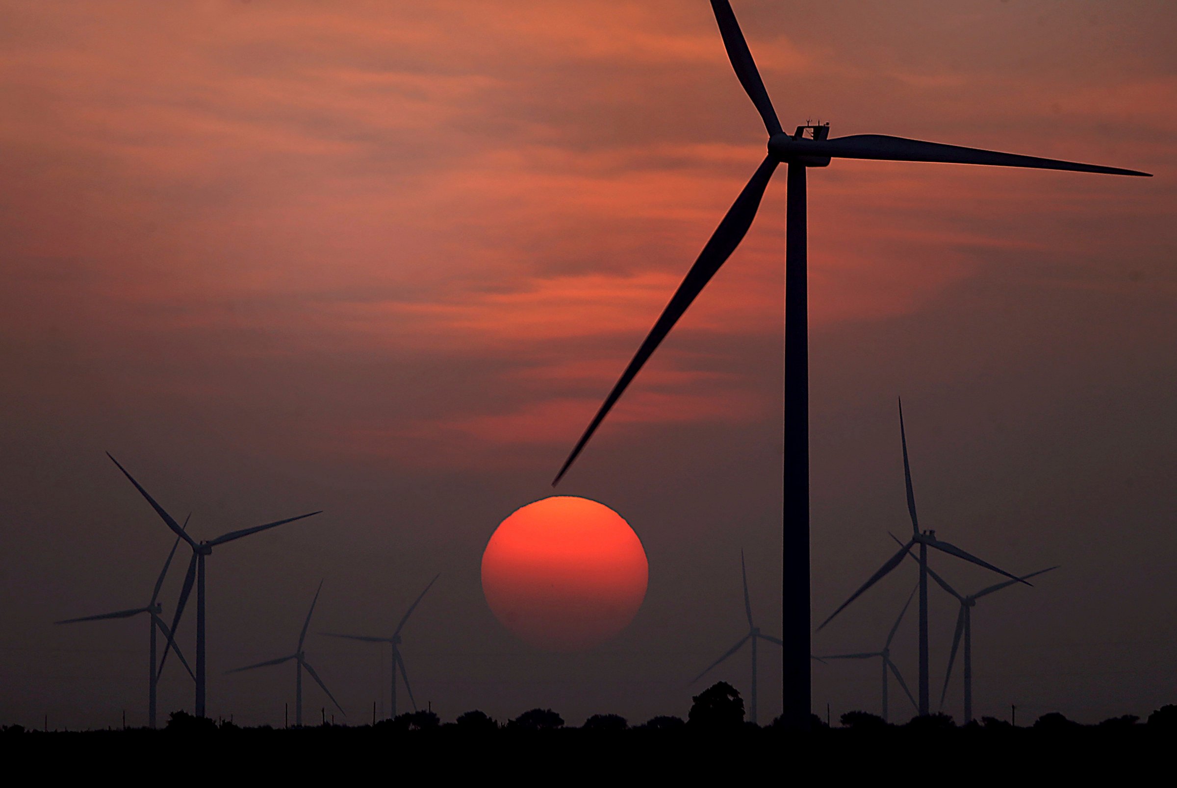 The sun sets on a windmill farm in McCook, Texas, on July 20, 2022. Photo: AP