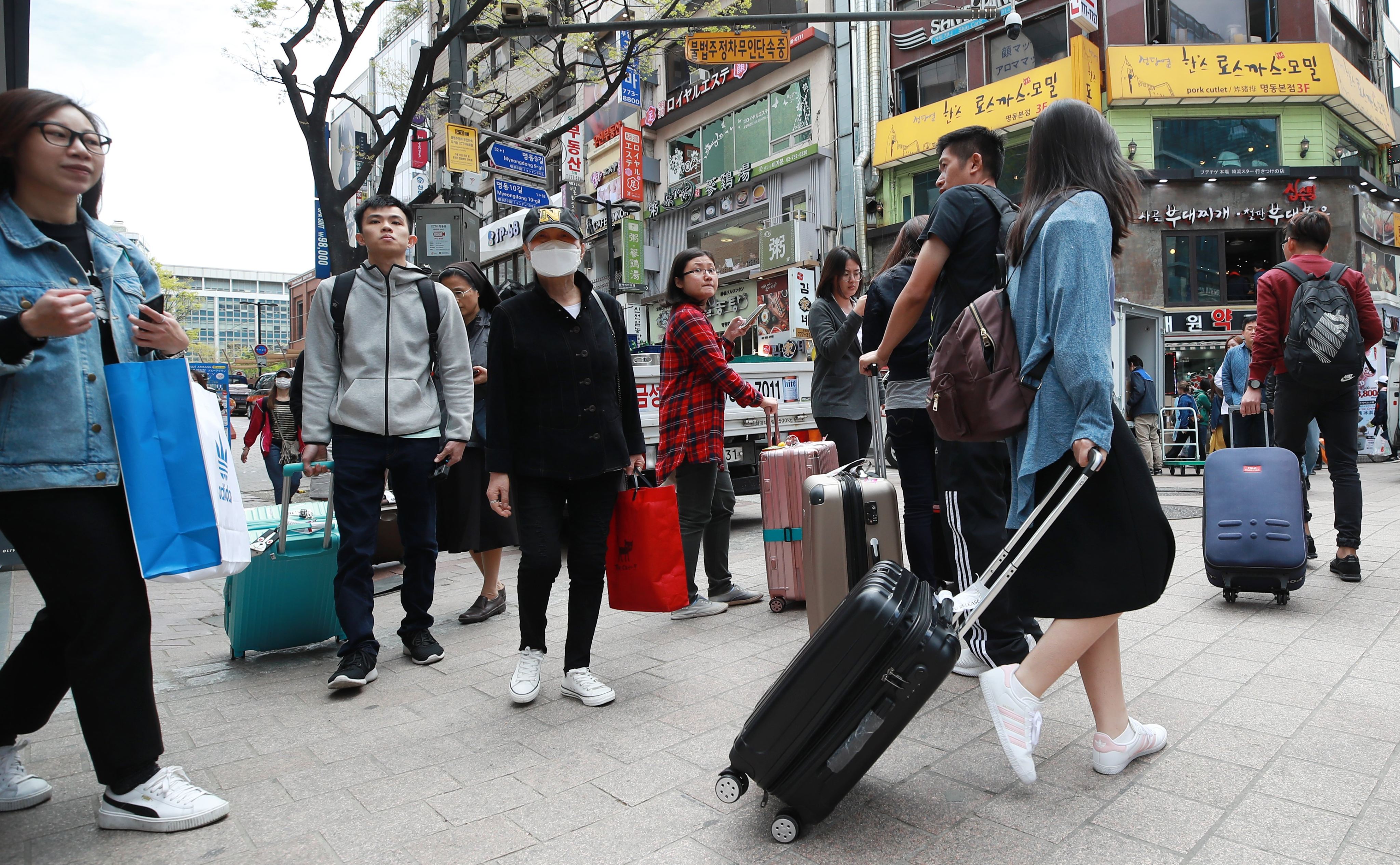 Chinese tourists carry their baggage on Myeongdong Street in downtown Seoul, South Korea. Photo: EPA-EFE/Yonhap
