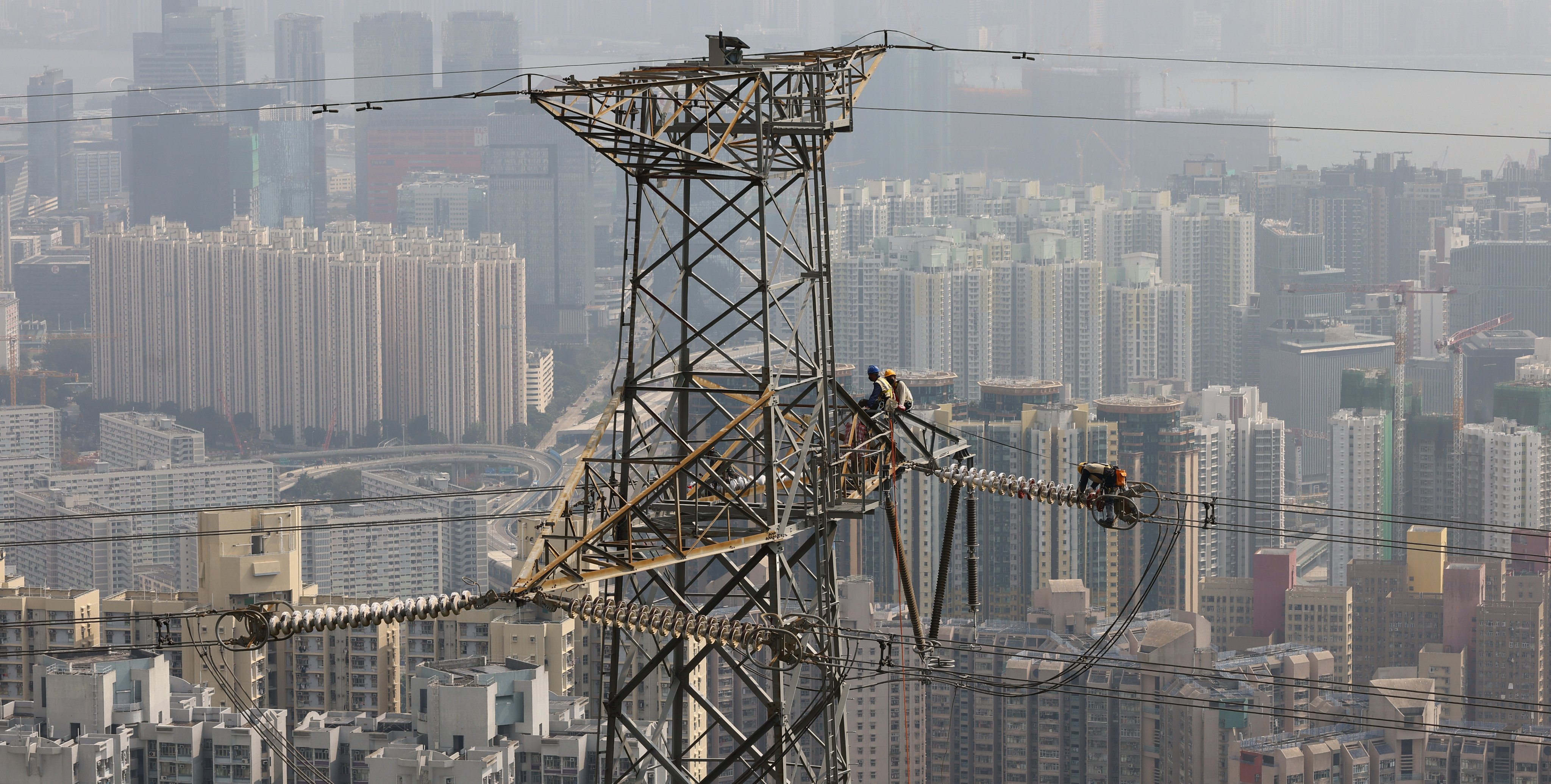 Workers on an electricity tower near Shatin Pass Road. Hong Kong’s two electricity companies have announced increases in rates, beginning in January 2025. Photo: Dickson Lee