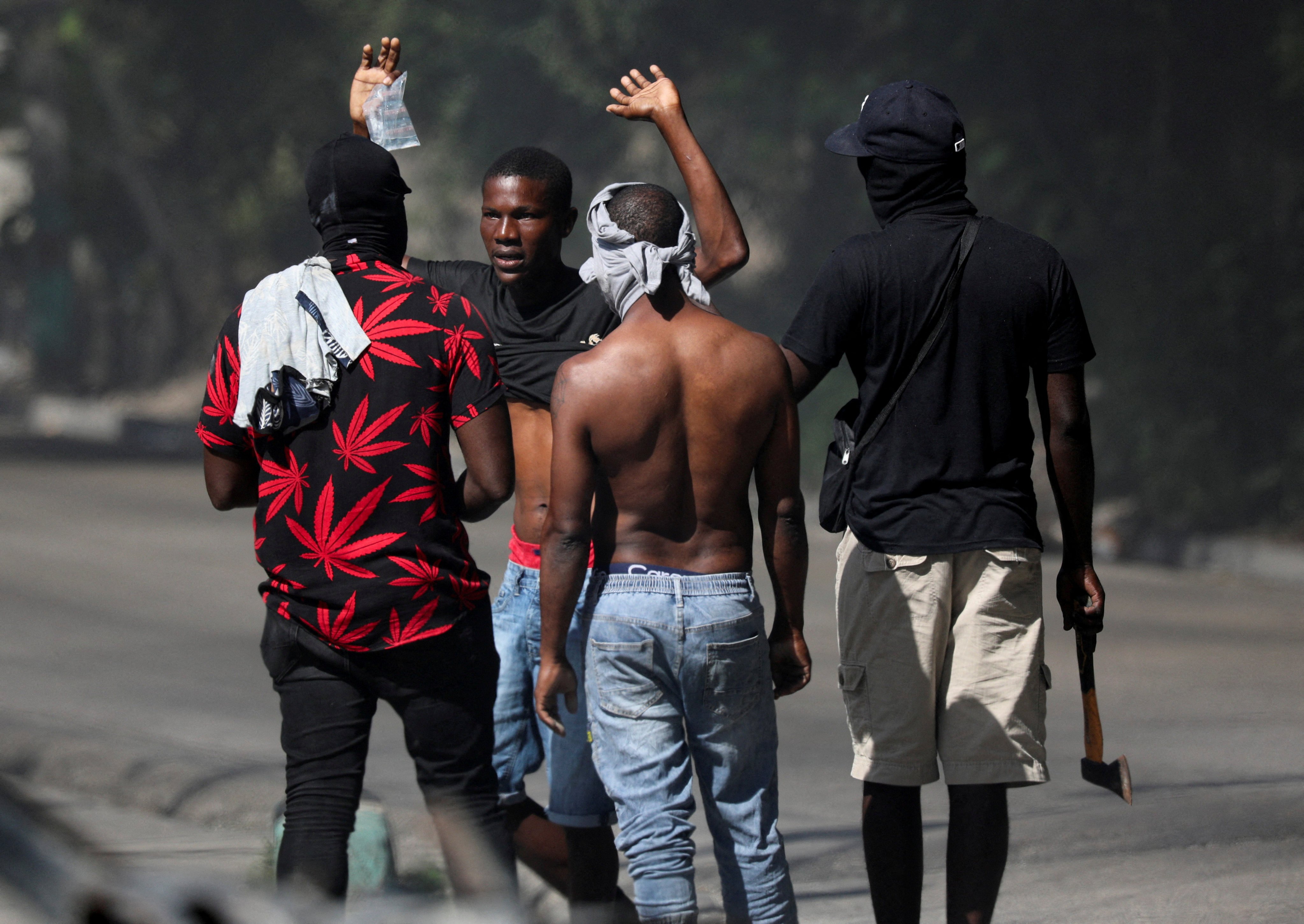 Residents question a person who is not from the neighbourhood after an attempted overnight attack by gangs. Photo: Reuters