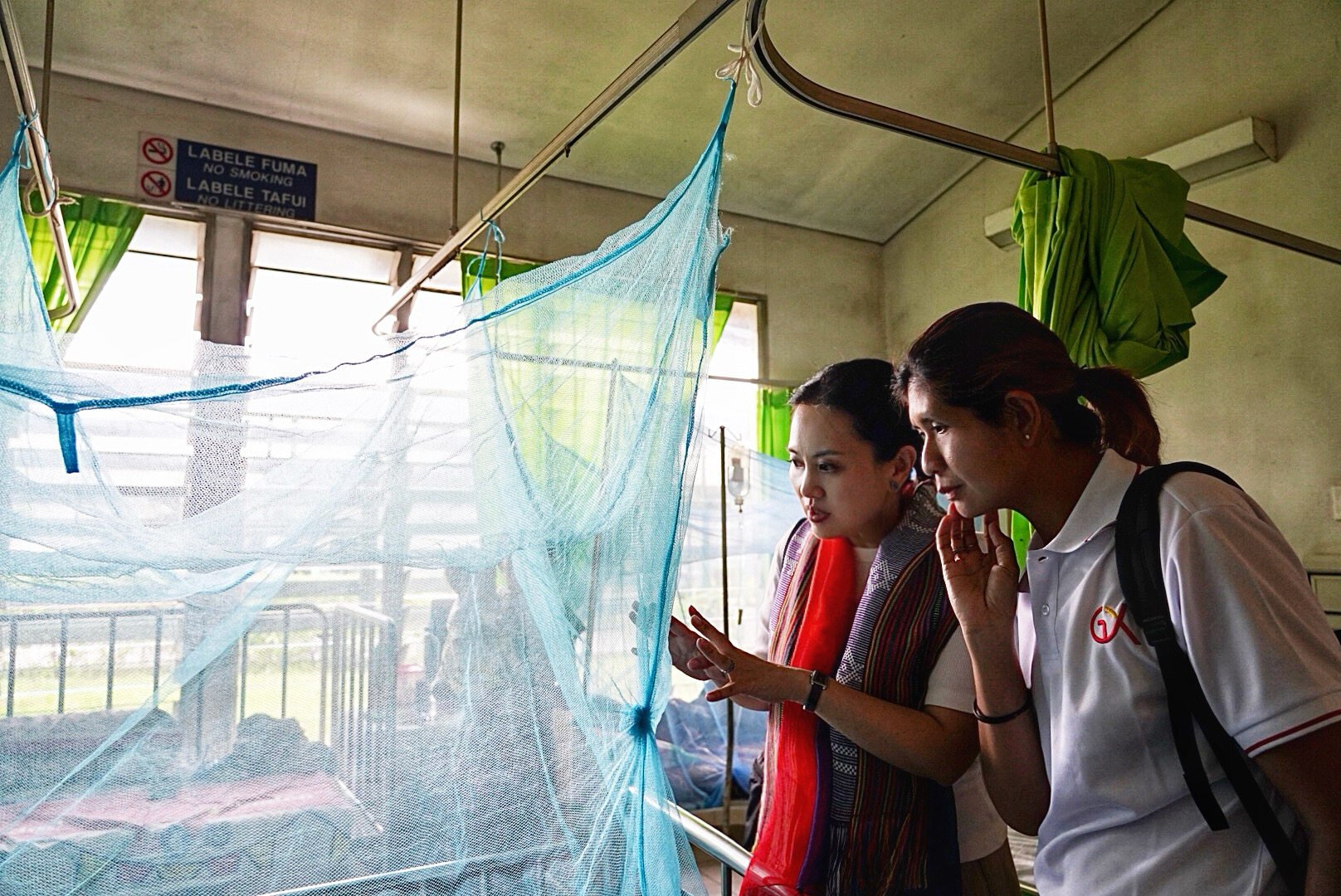 Emily Chan (left) checks mosquito netting with a medical worker in East Timor. Photo: Handout