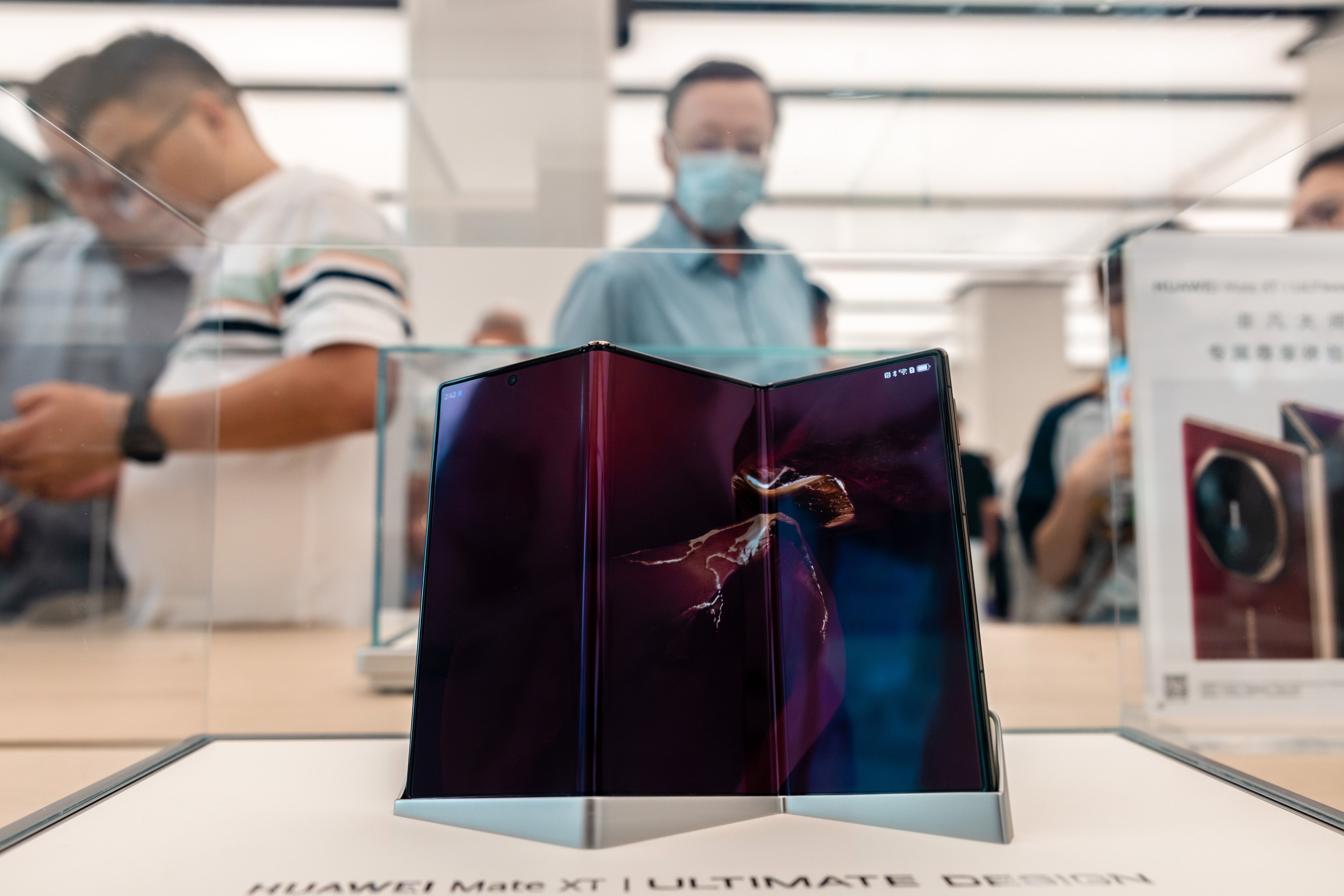 Customers look at the new Mate XT smartphone on display in the Huawei store in Shanghai, September 14, 2024. Photo: EPA-EFE