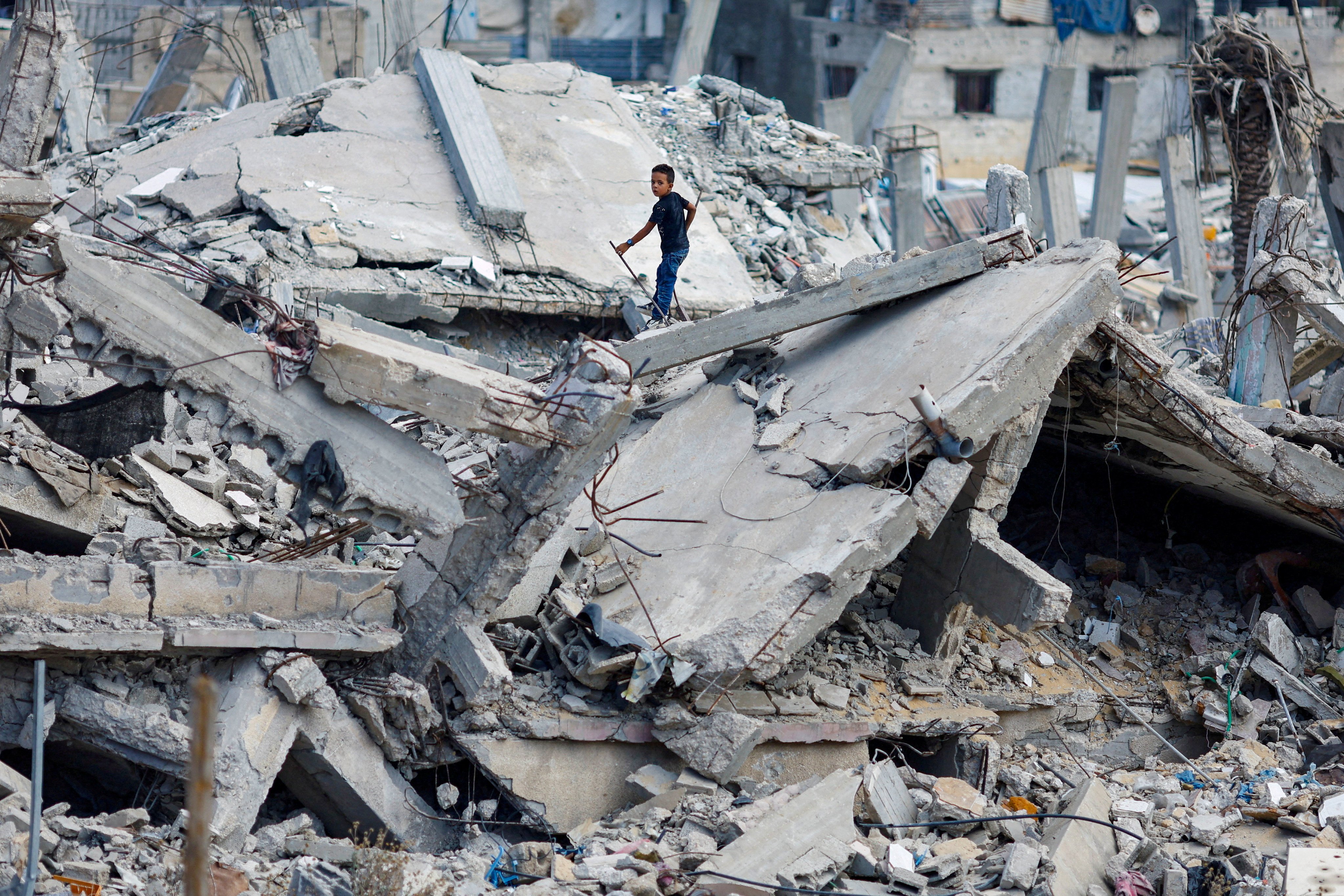 A Palestinian boy stands on the rubble of a house destroyed in Israel’s military offensive in Khan Younis in the southern Gaza Strip on October 7. Photo: Reuters