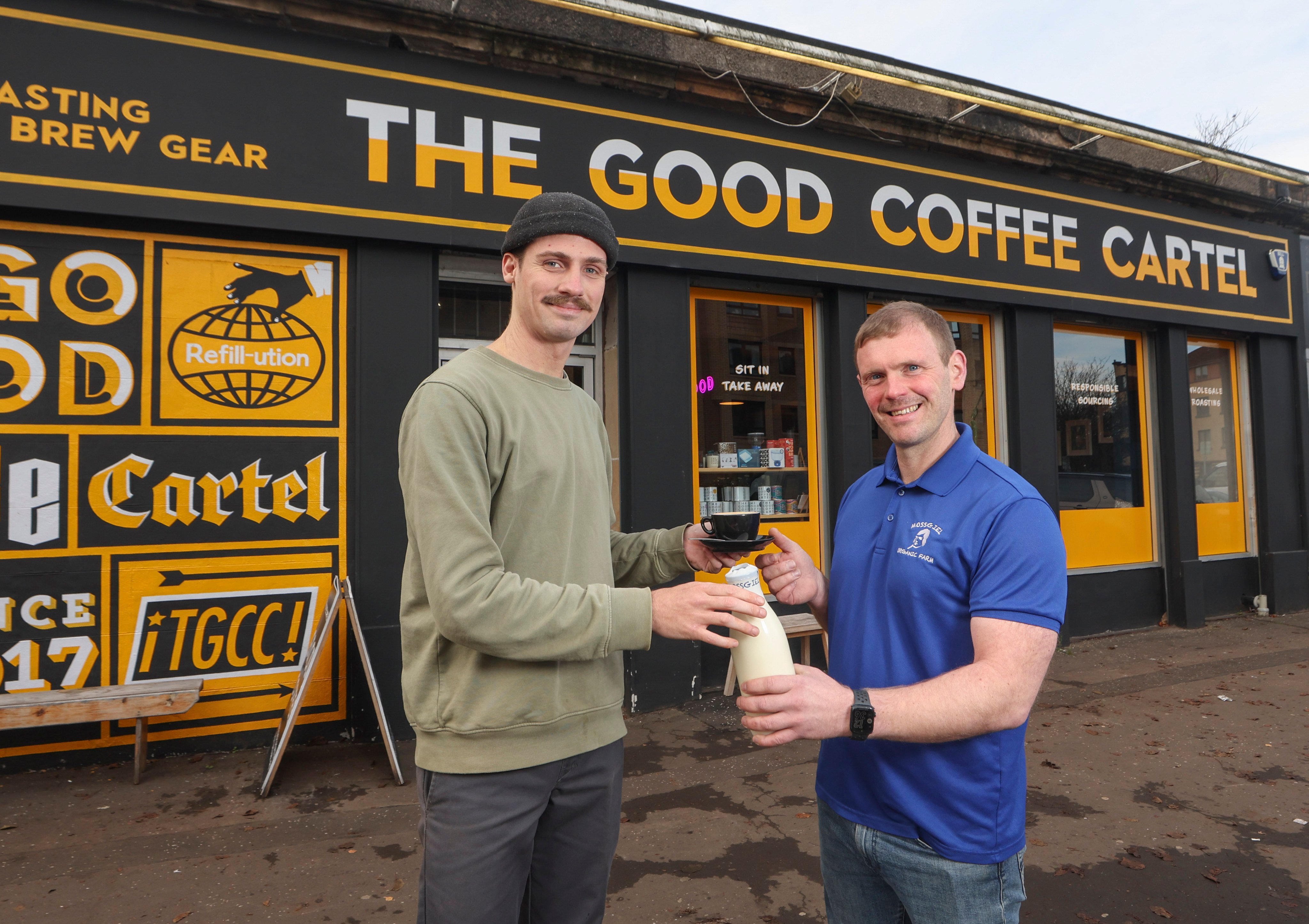 Farmer and owner of Mossgiel Organic Farm Bryce Cunningham (right) gives a bottle of milk to barista Jacob Smith, outside The Good Coffee Cartel in Glasgow. Photo:  via AP