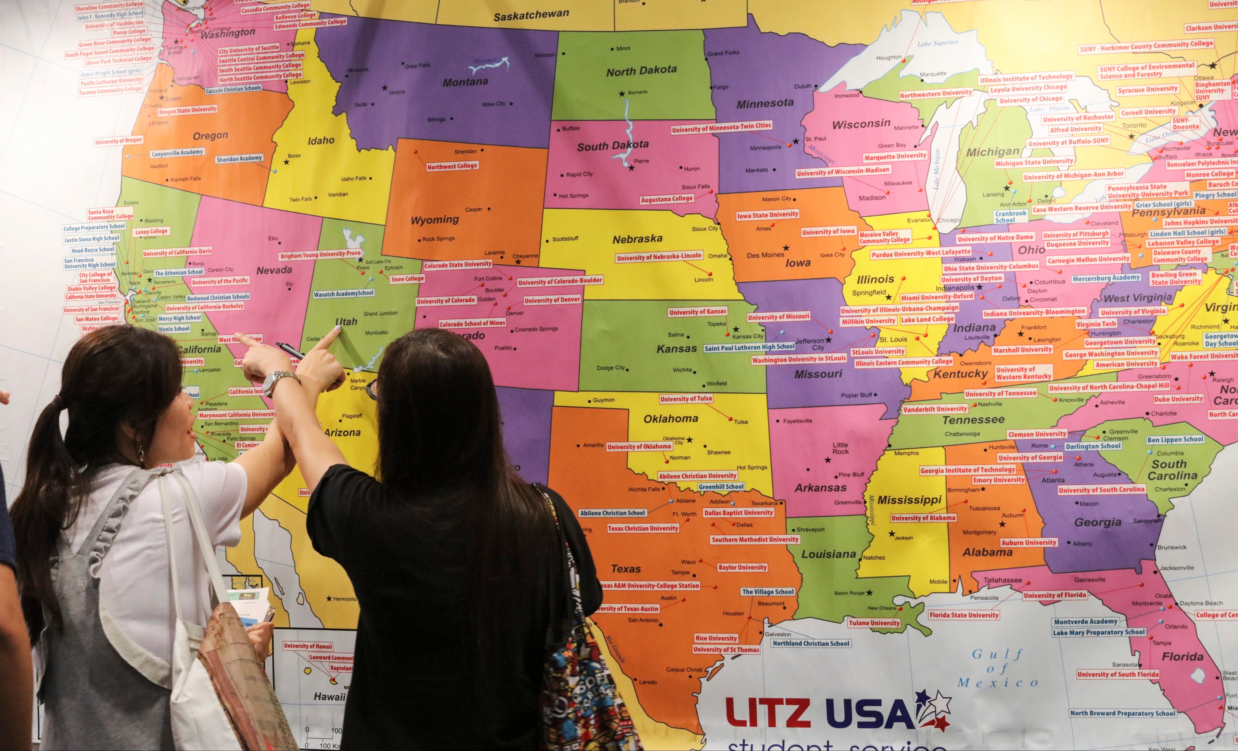 People attending an education expo in Hong Kong look at a map of universities in the US. Photo: Felix Wong