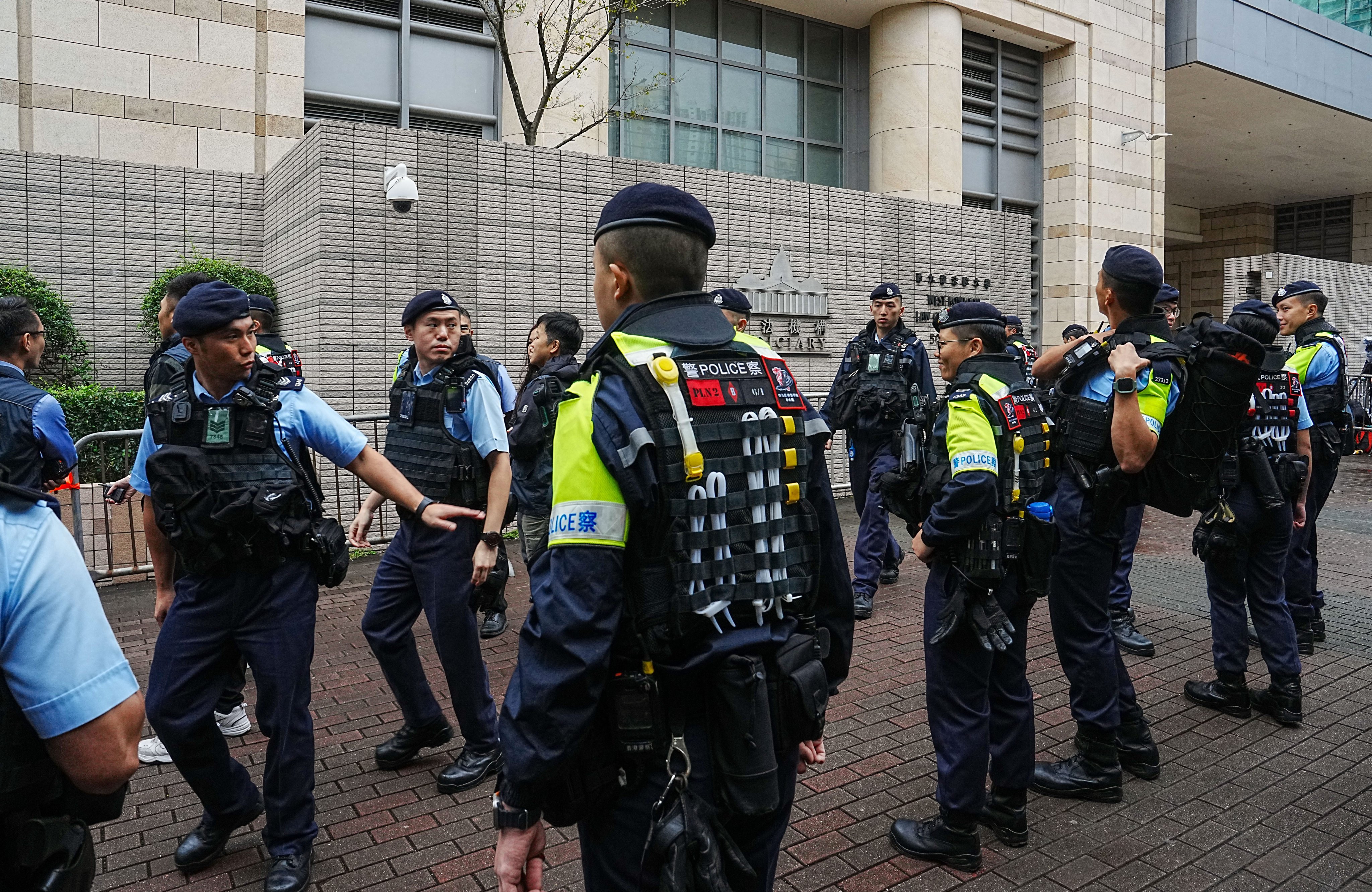 Police officers are stationed outside the court during the sentencing of 45 former opposition camp members. Photo: Elson Li