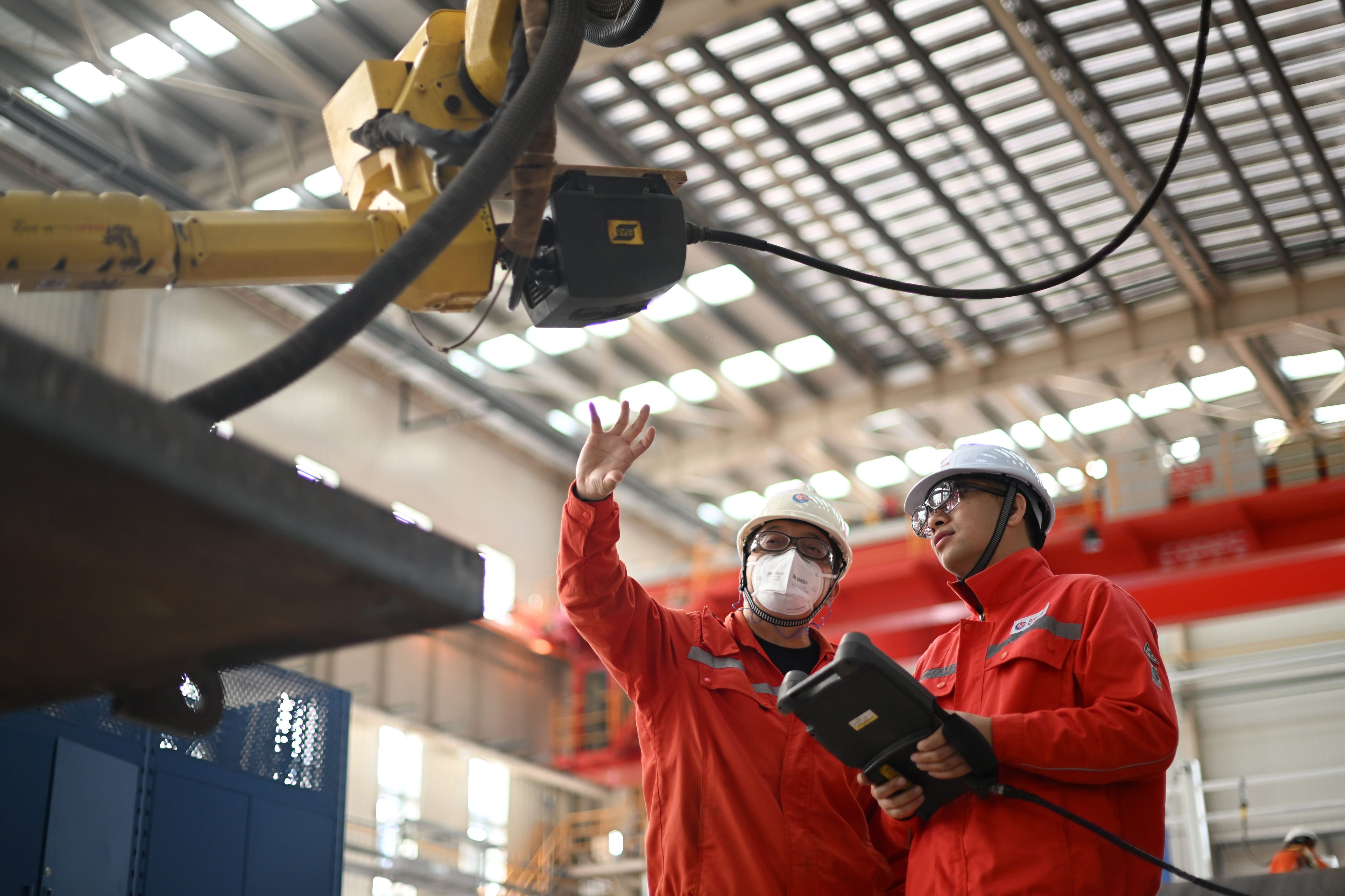 Technicians inspect a welding robot at a pipeline workshop of the China Offshore Oil Engineering Company in Tianjin, October 30, 2024. Photo: Xinhua