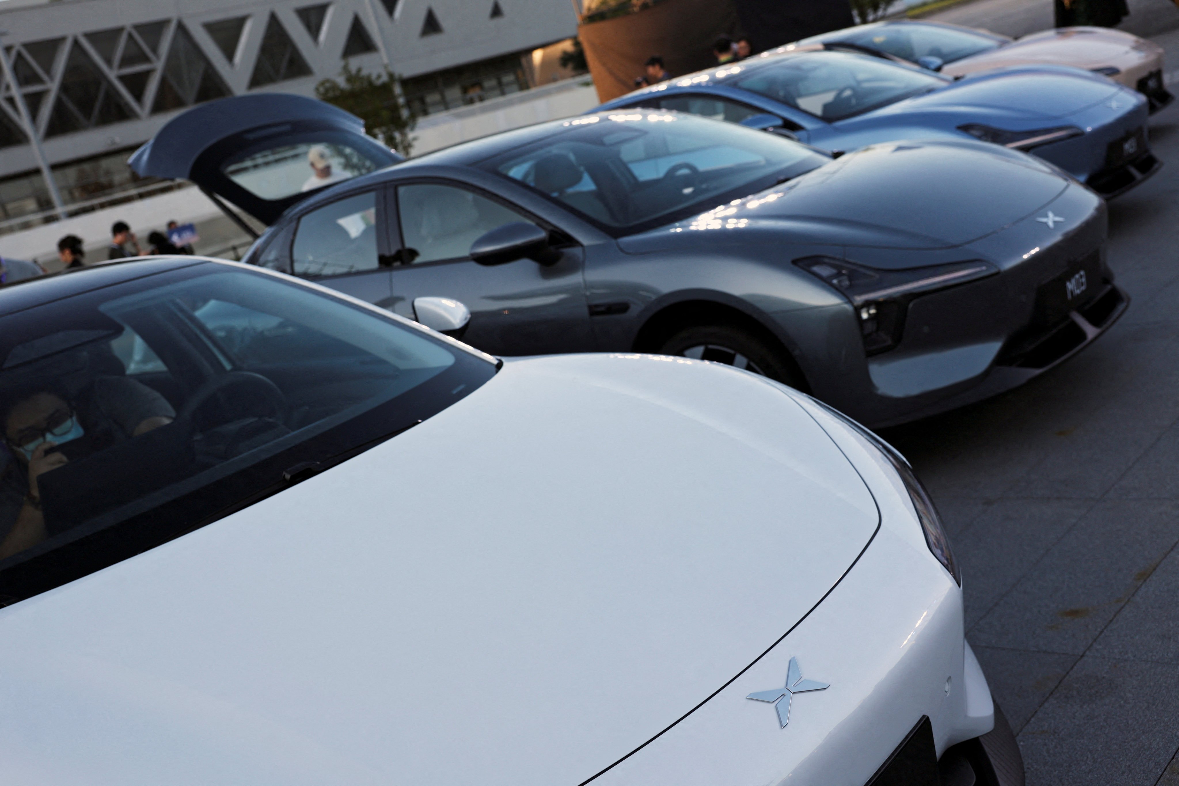 Visitors look at Mona M03 electric vehicles (EVs), displayed at an XPeng launch event in Beijing on August 27, 2024. Photo: Reuters