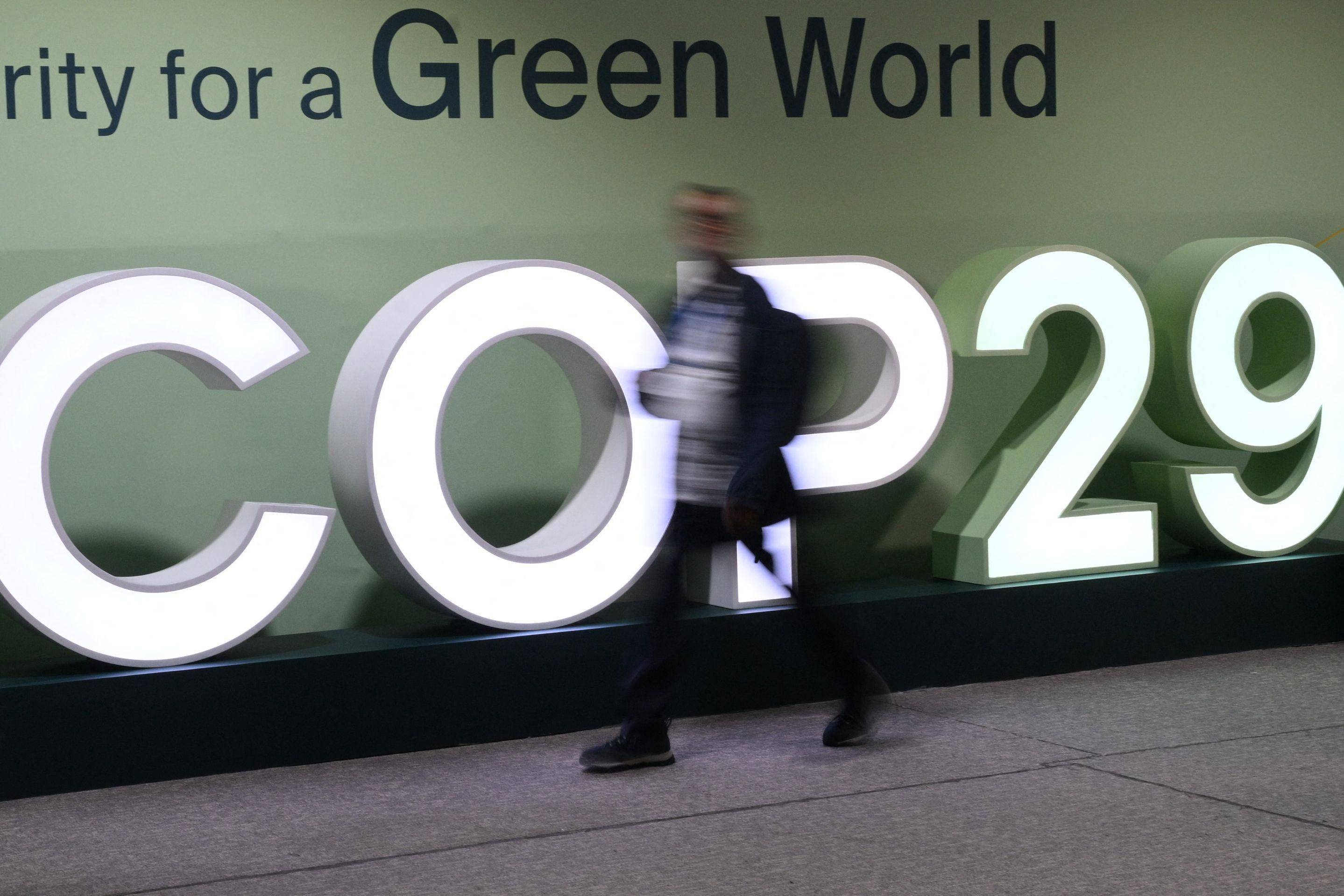 Attendees walk past the Cop29 logo at the summit in Baku, Azerbaijan, on November 21. Photo: AFP