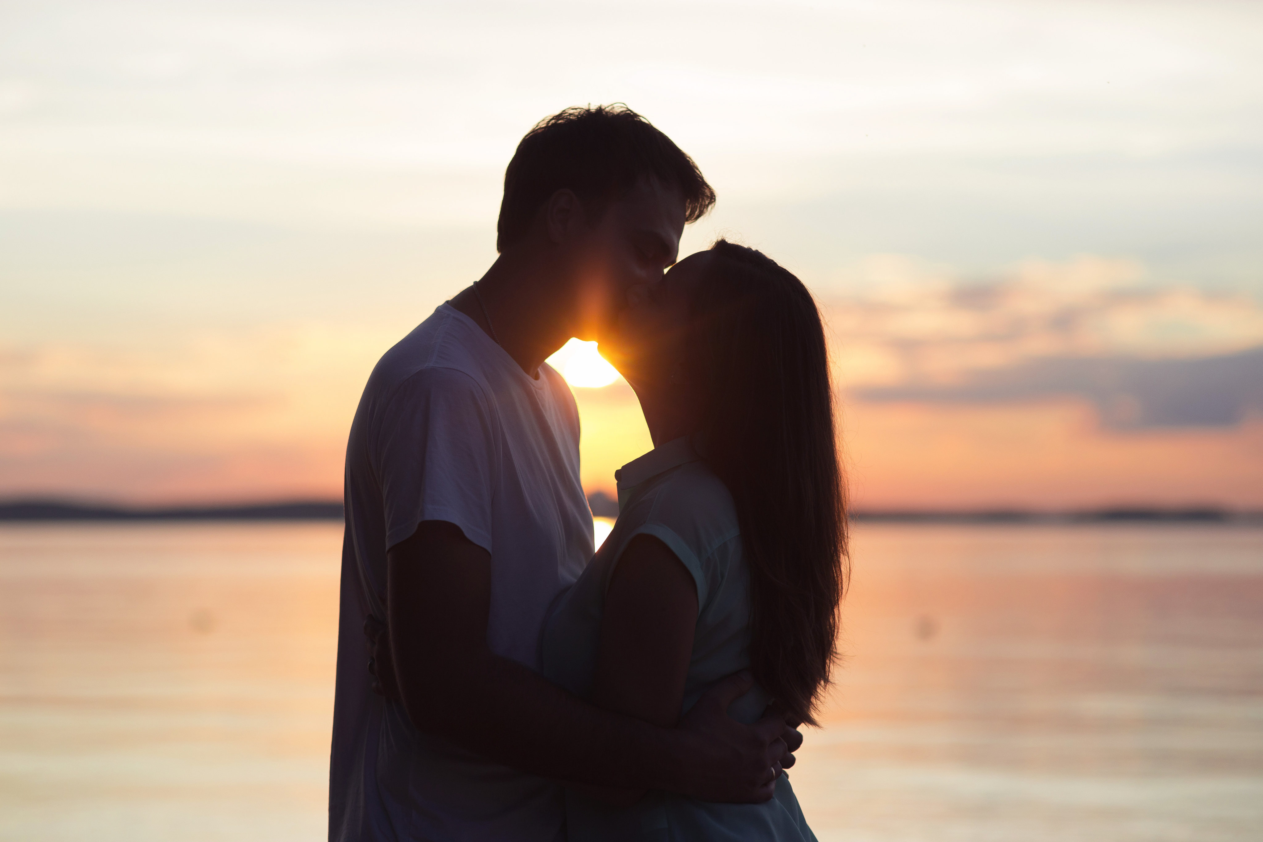 A loving young couple kissing at sunset. Photo: Shutterstock