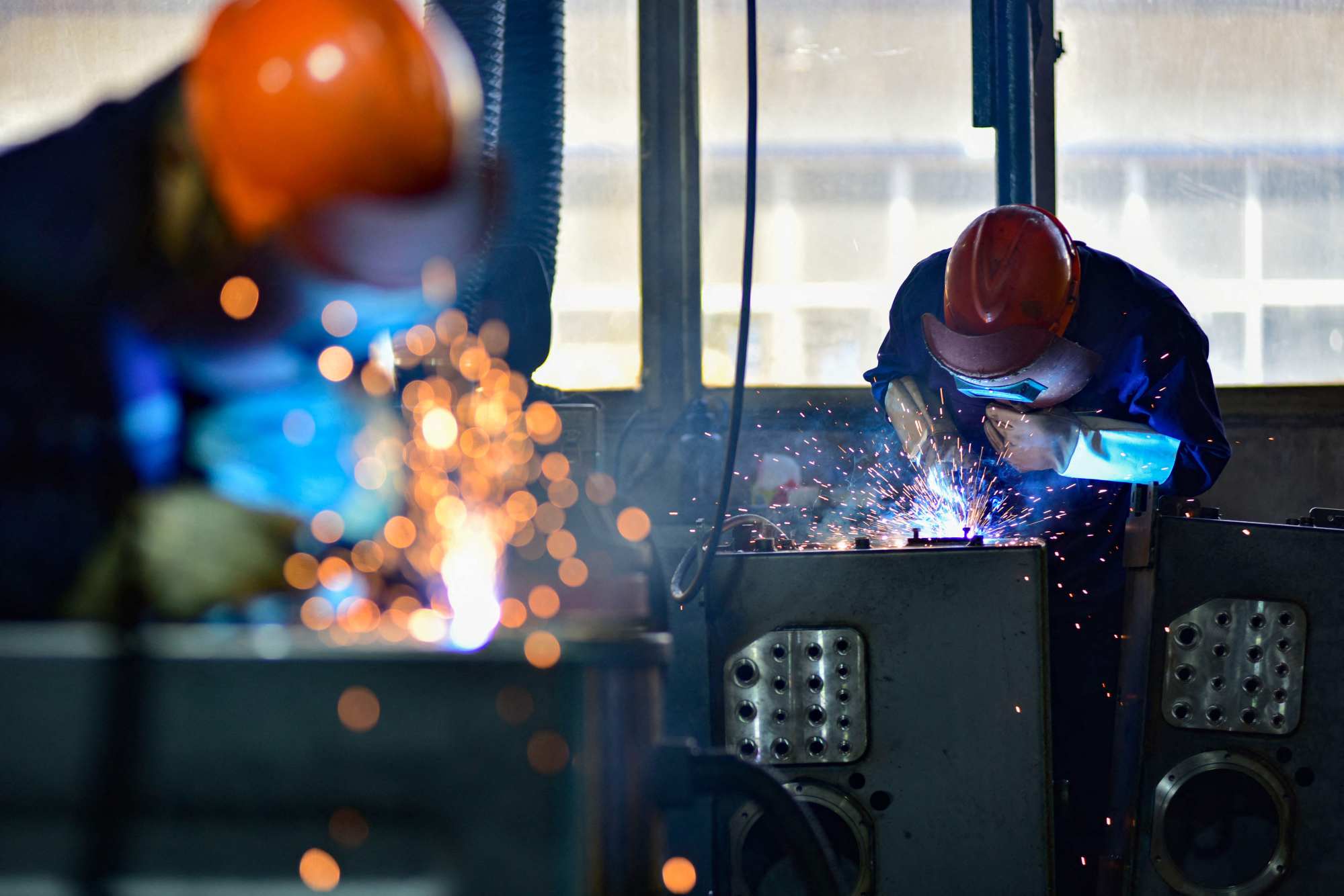 Workers weld parts at a factory producing cabs for excavators in Qingzhou, in Chinas eastern Shandong province, on October 31, 2024. Photo: AFP