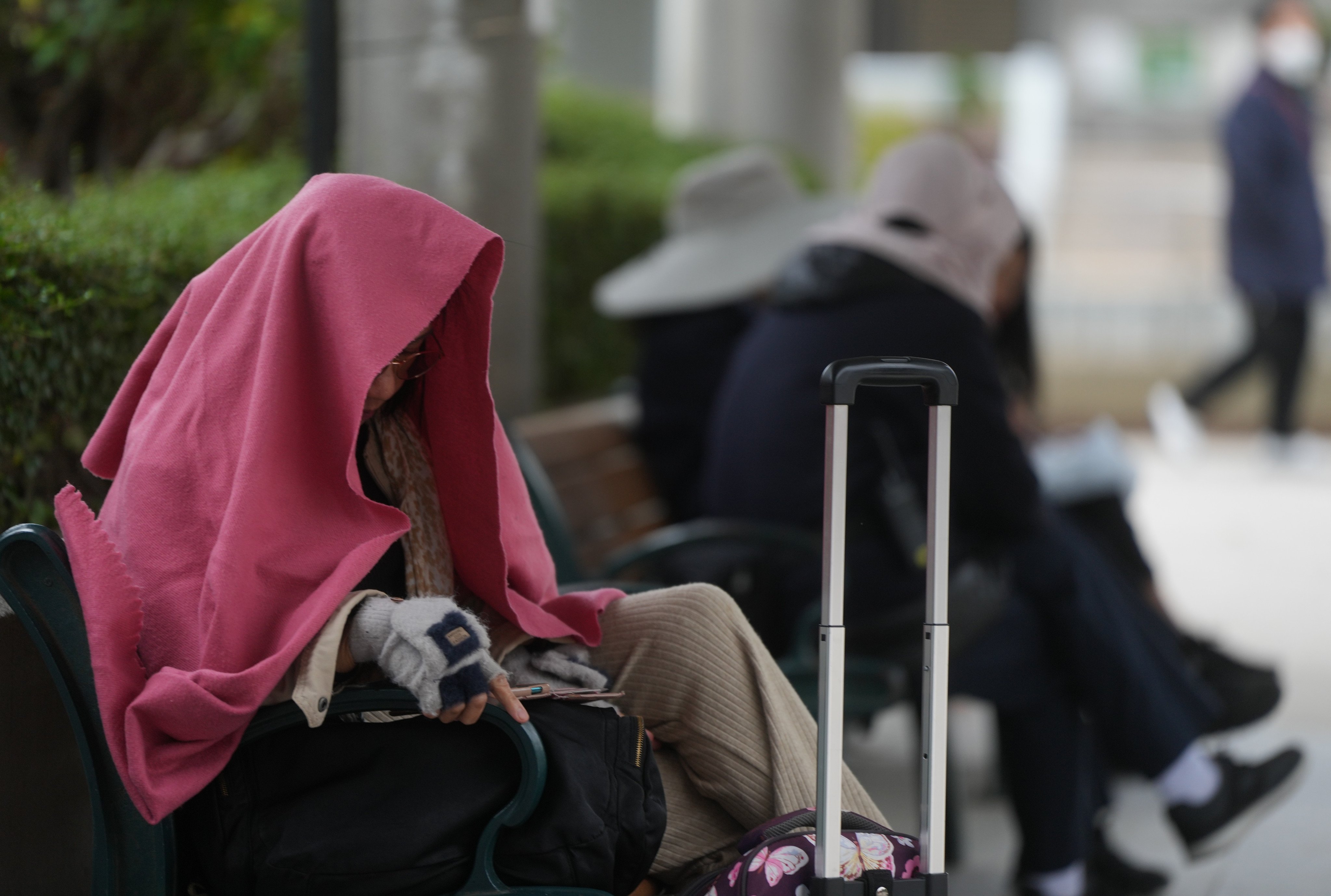 A woman covers up to protect against cold weather in Sha Tin. Photo: Sam Tsang