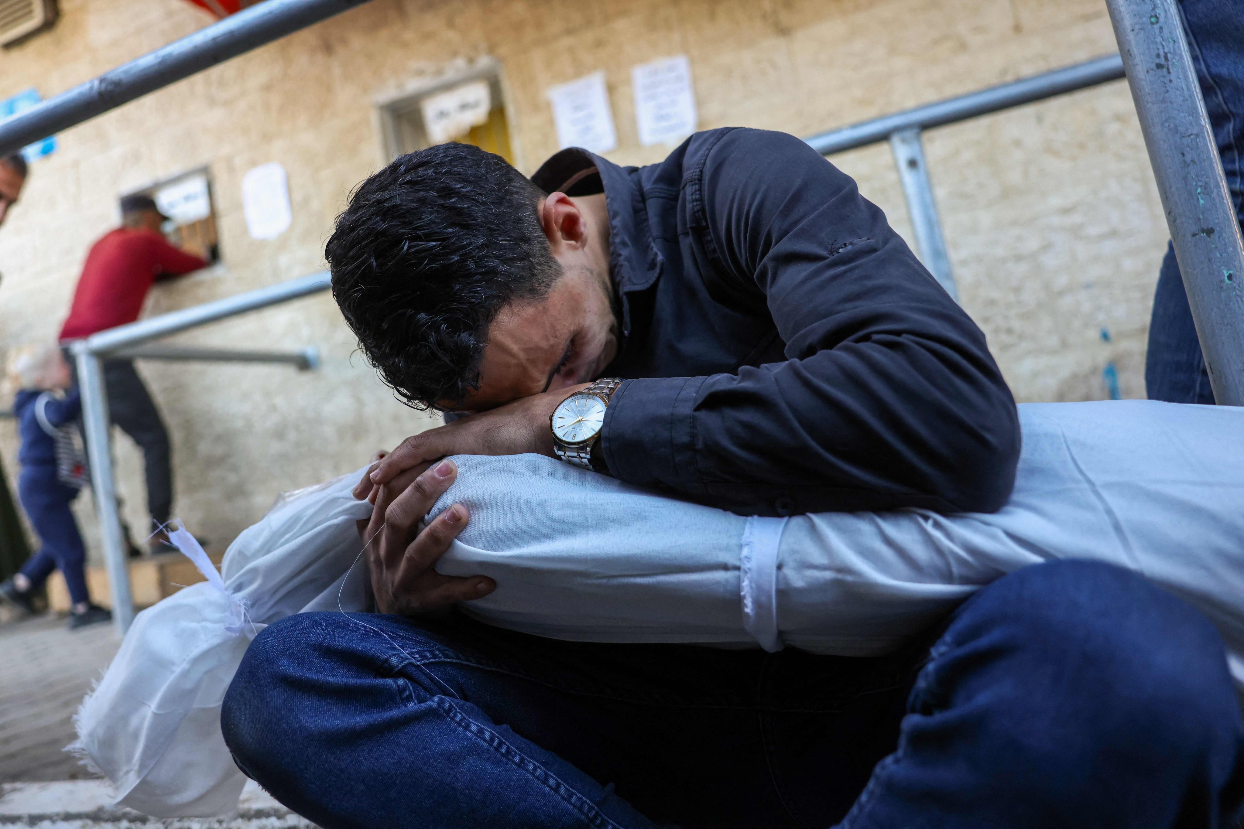 A man mourns holding the body of a child, who was killed in an Israeli strike, at the al-Aqsa Martyrs Hospital in Deir al-Balah in Gaza. Photo: AFP