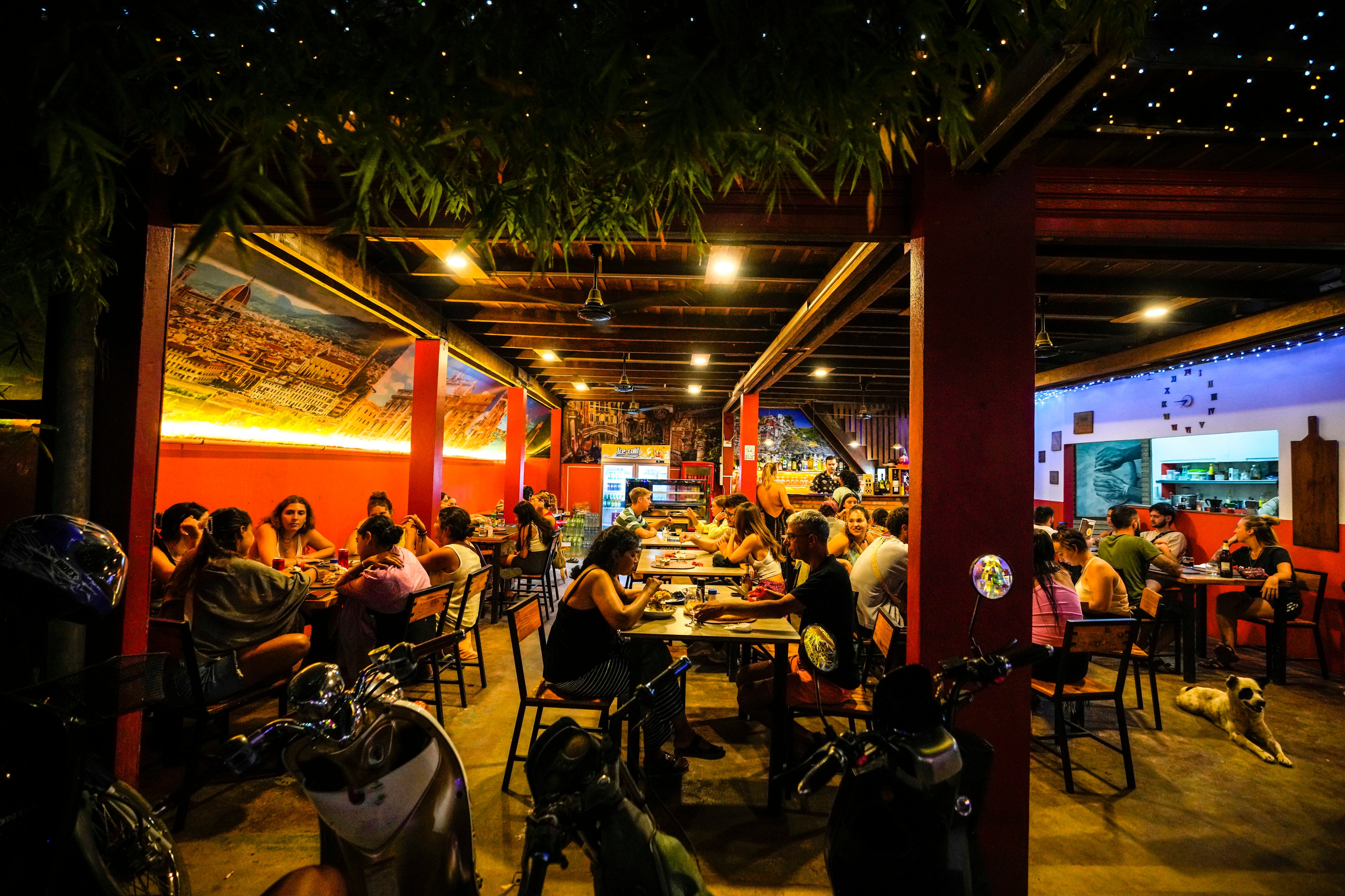 Foreign tourists have drinks and pizza at a restaurant in Vang Vieng, Laos, on Tuesday. Photo: Ap