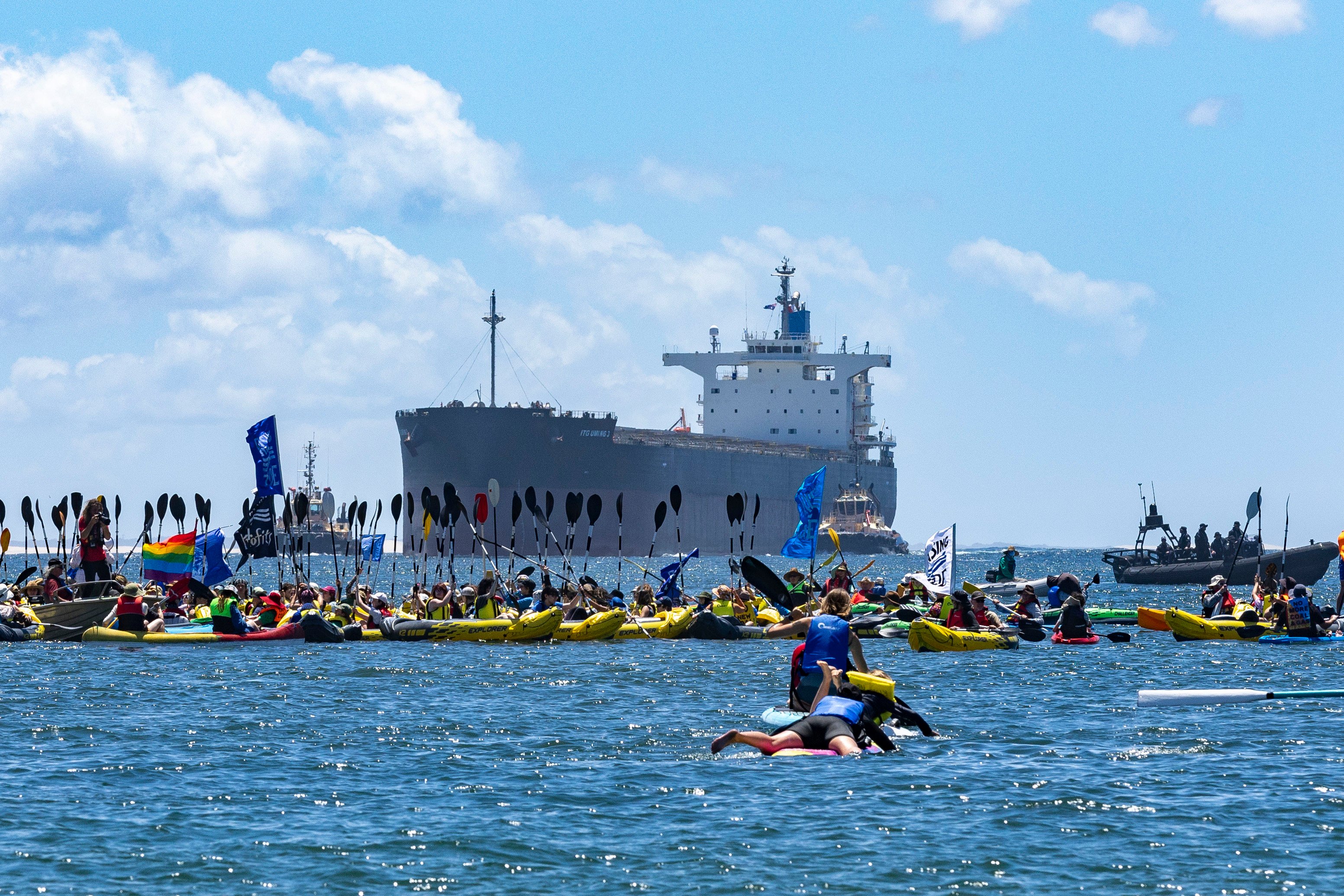 Protesters gather at the mouth of the harbour during a coal export demonstration at Nobbys Beach. Photo: DPA