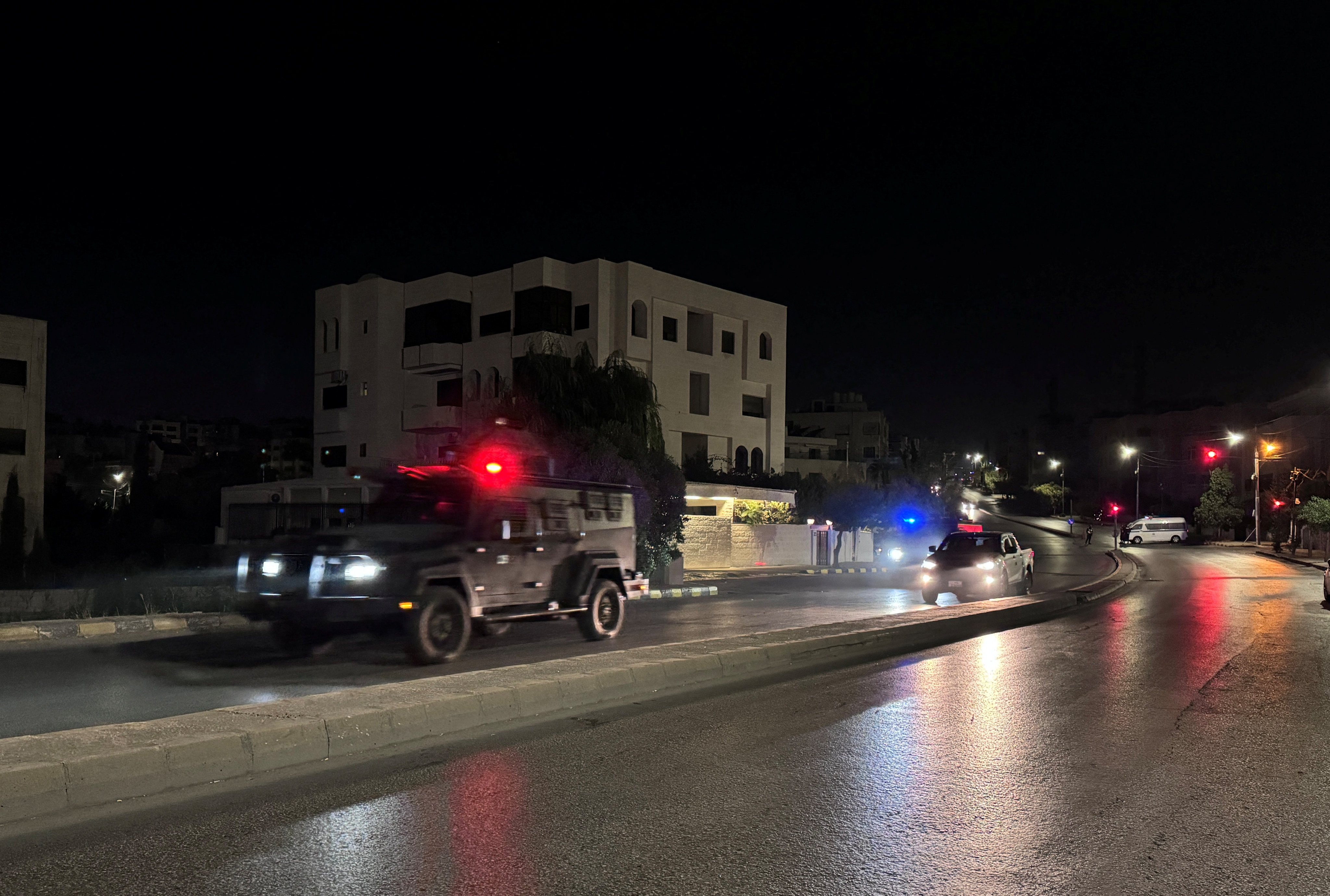 Police vehicles on a street near the Israeli embassy in Amman, Jordan following the shooting. Photo: Reuters