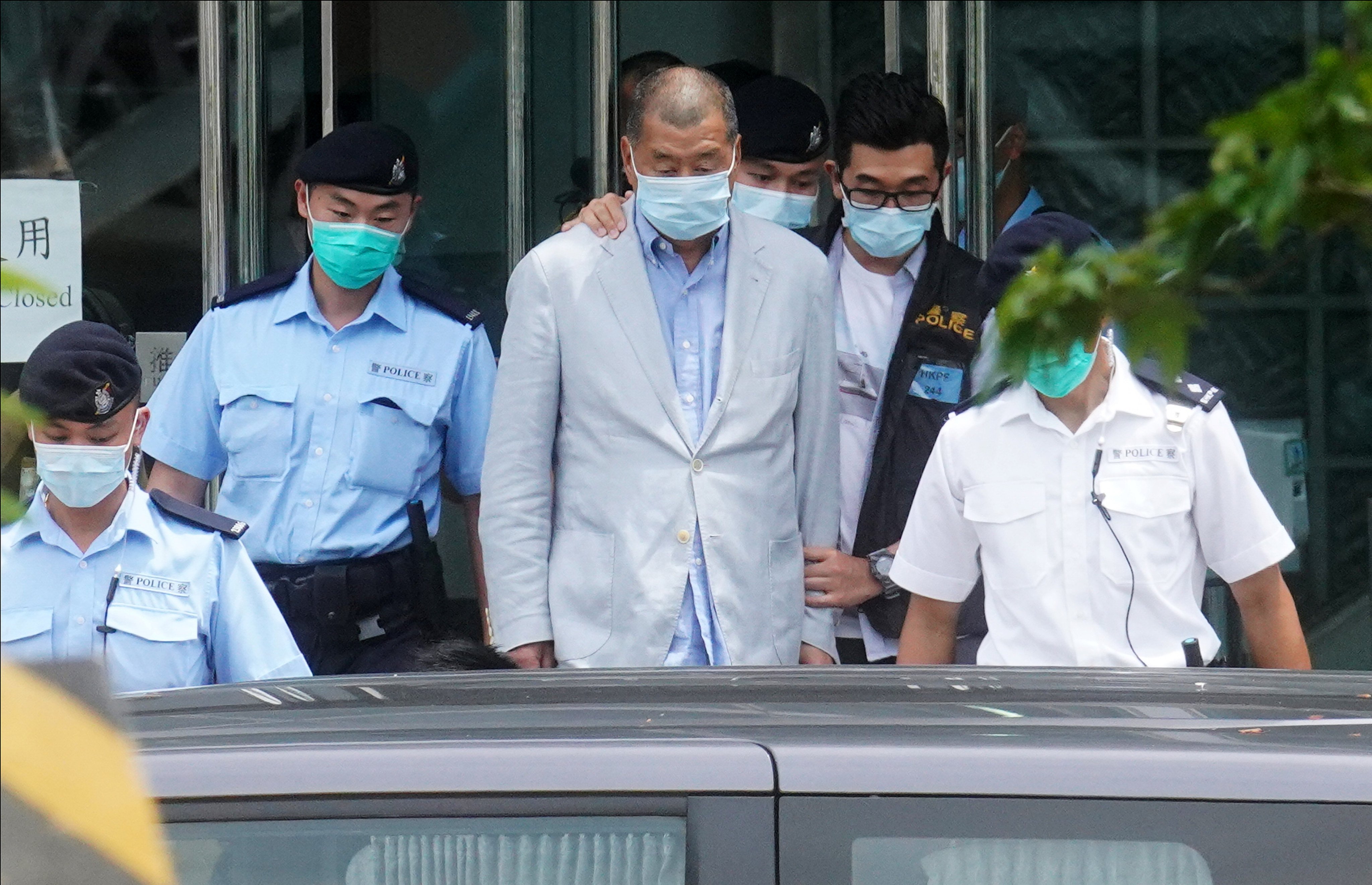 Officers escort Jimmy Lai during a police raid on Apple Daily’s office in August 2020. Photo: Winson Wong