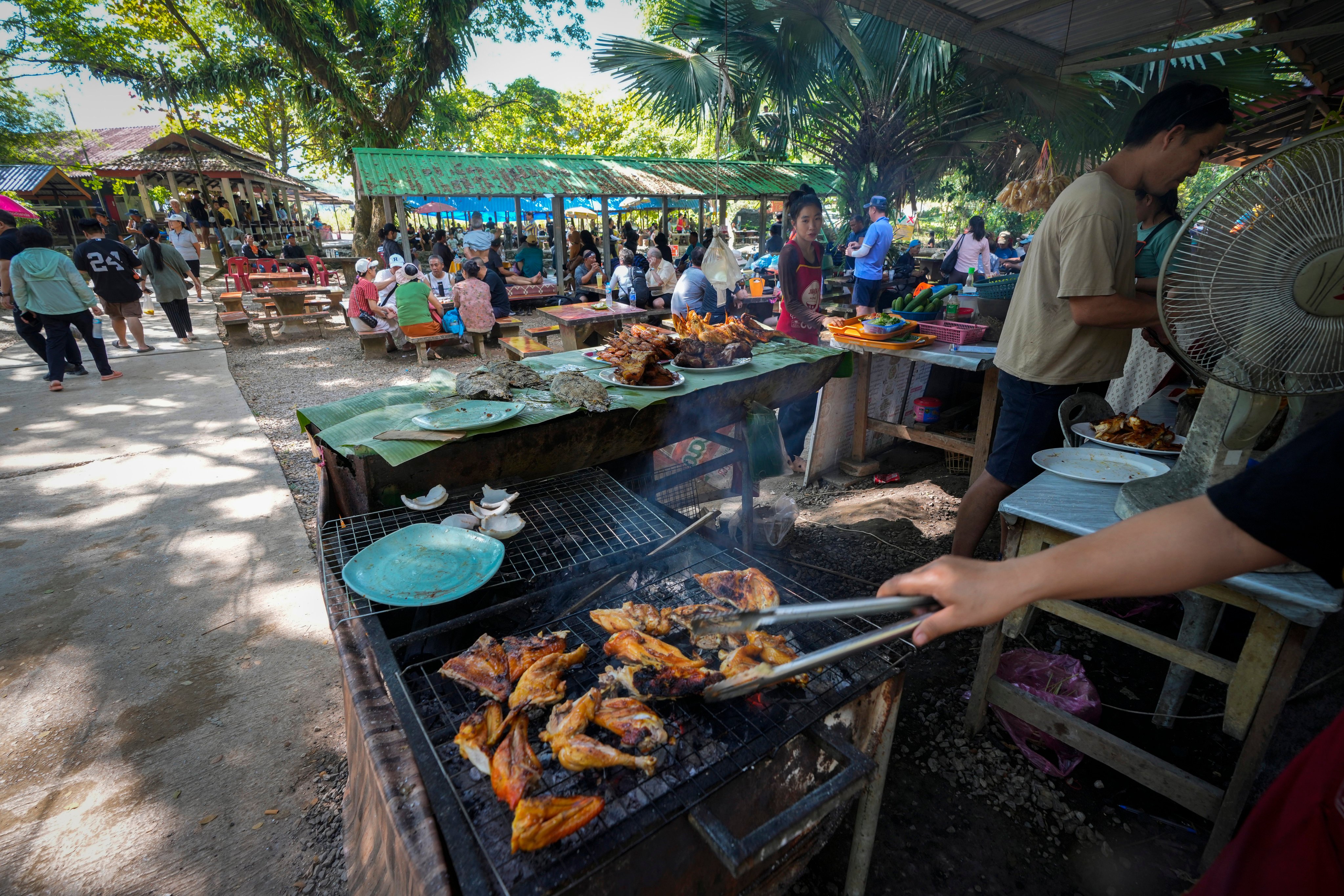 Foreign tourists relax with beer and food in Blue lagoon, in Vang Vieng, Laos. Photo: AP