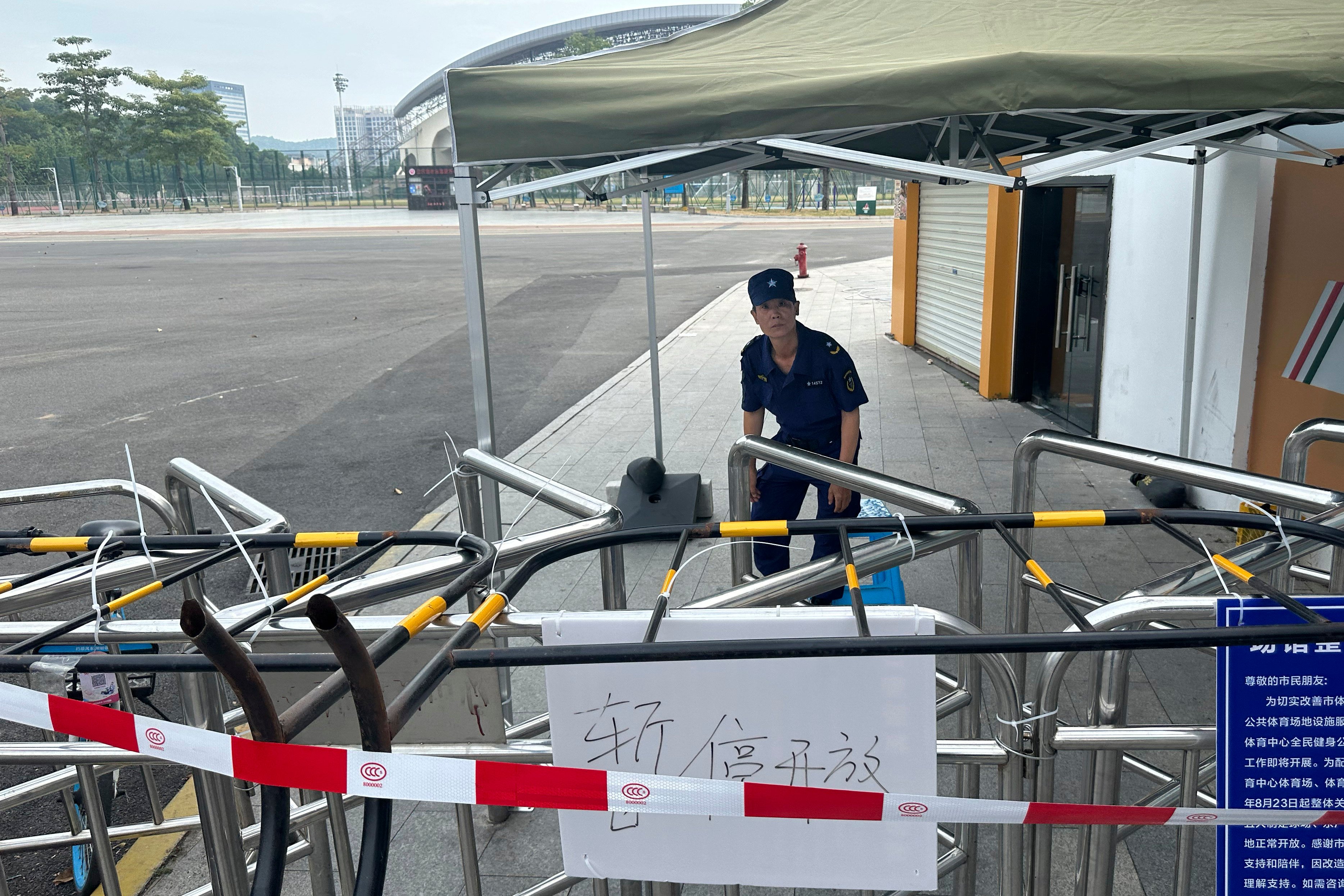 A security guard keeps watch on Wednesday near the entrance to a plaza in Zhuhai, China, where days earlier a man rammed his car into a crowd of people. Photo: AP