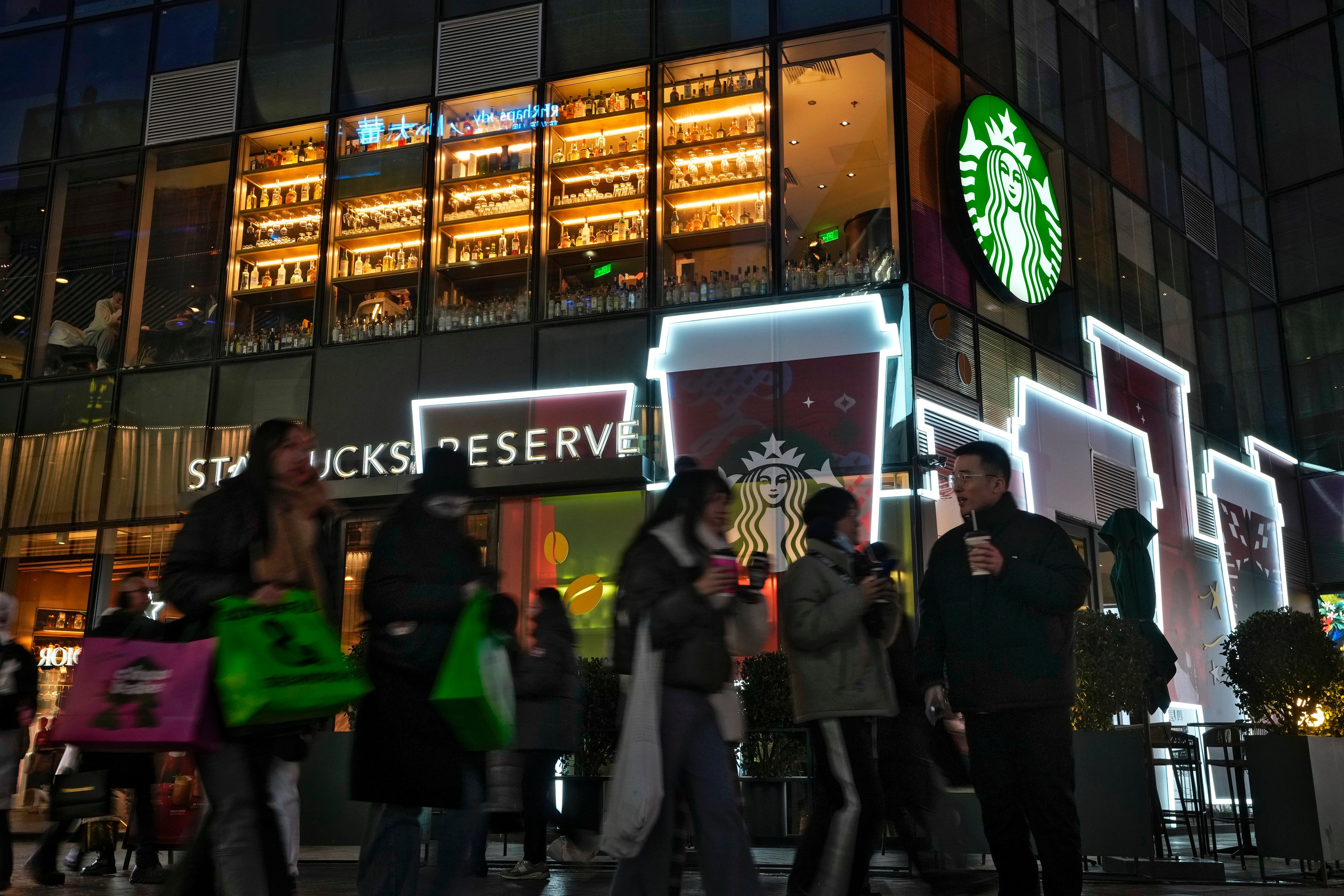 Shoppers walk by a Starbucks cafe at an outdoor shopping mall in Beijing, December 23, 2023. Photo: AP