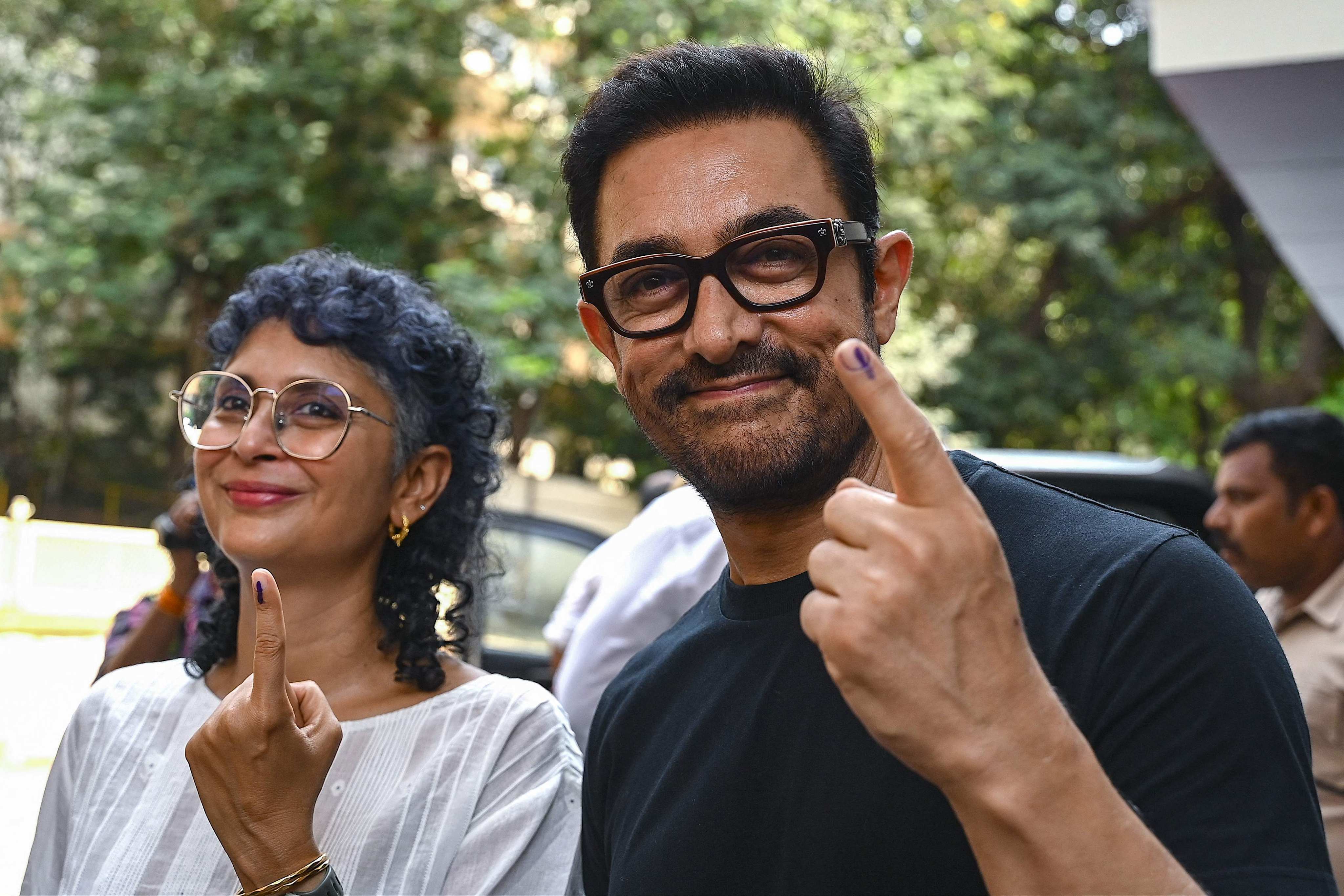 Bollywood actor Aamir Khan and director Kiran Rao (left)) display ink marked fingers after casting their votes at a polling station on May 20. Photo: AFP