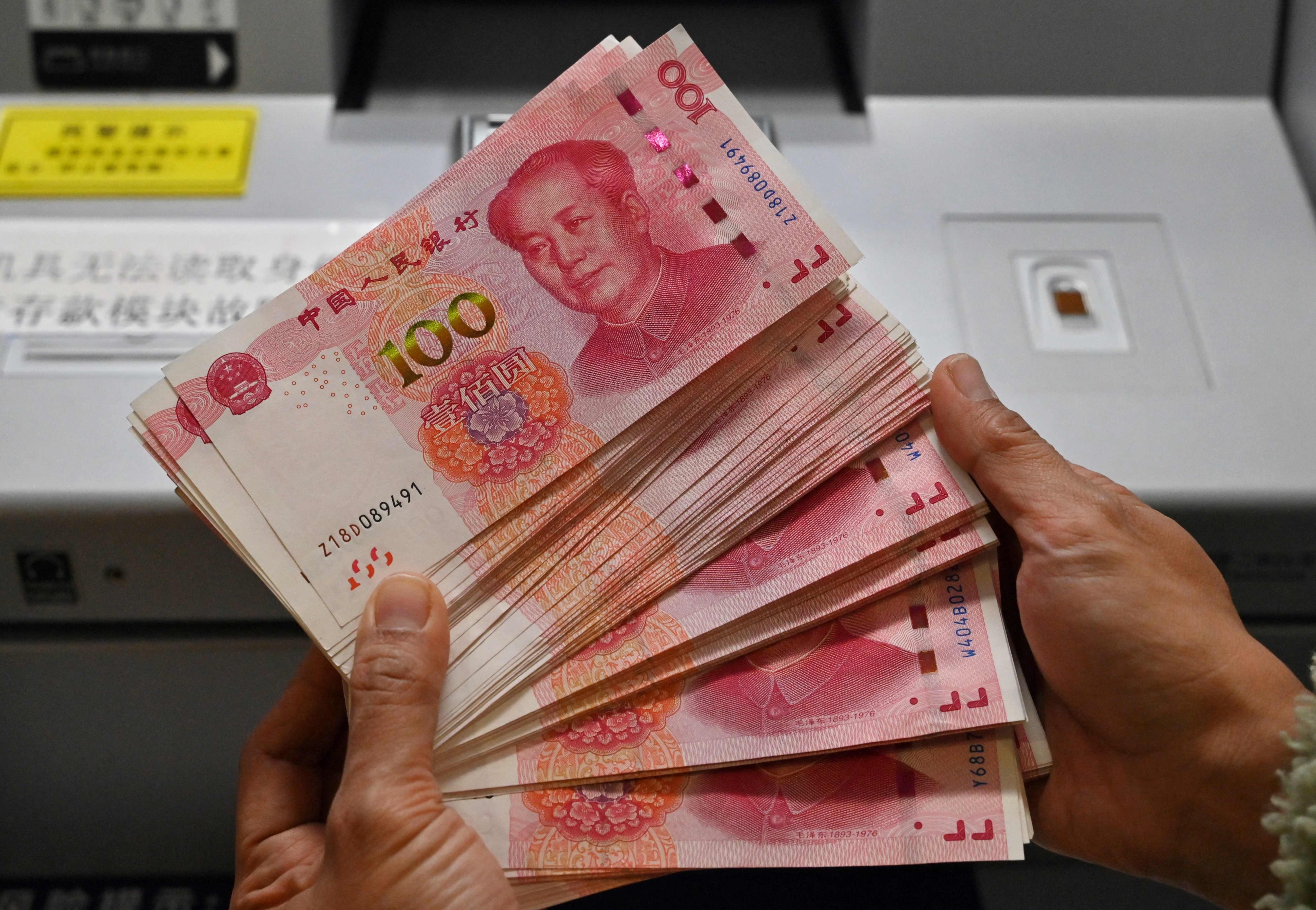 An employee counts yuan notes at a bank in Beijing. Photo: AFP