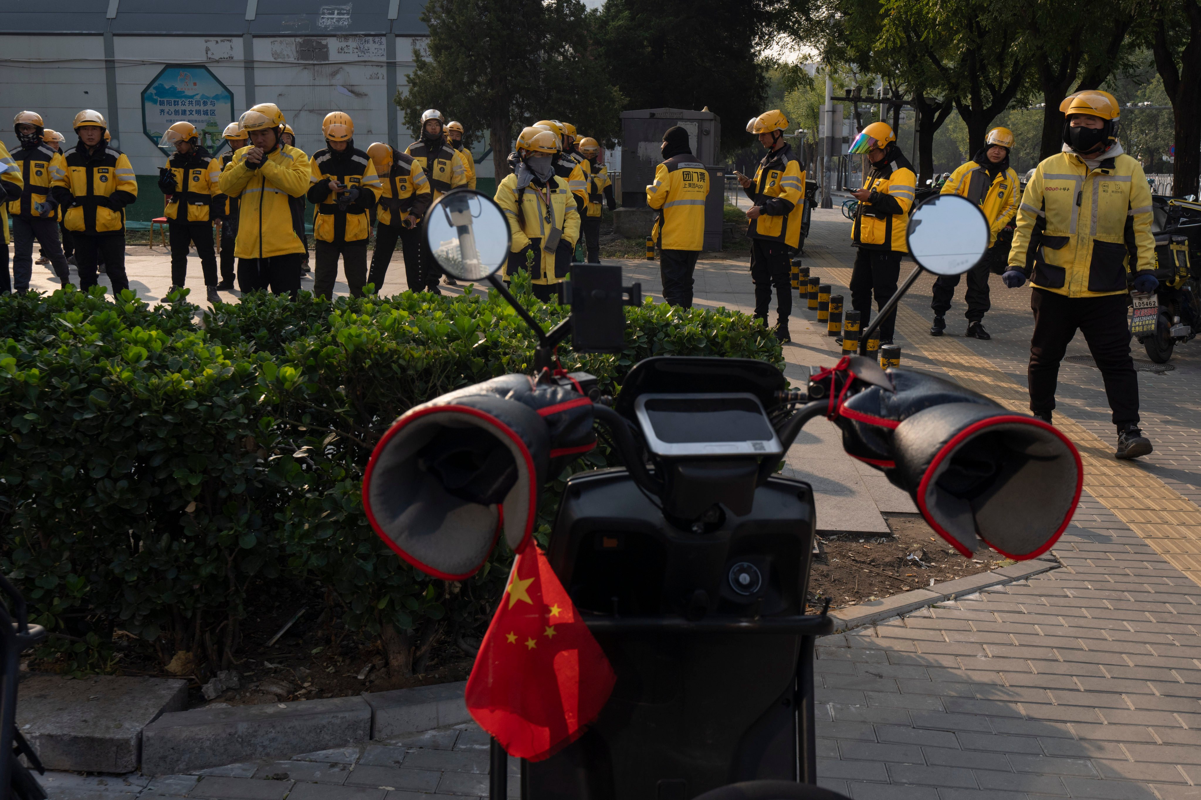 Food delivery workers prepare for the lunch hour in Beijing. Photo: AP