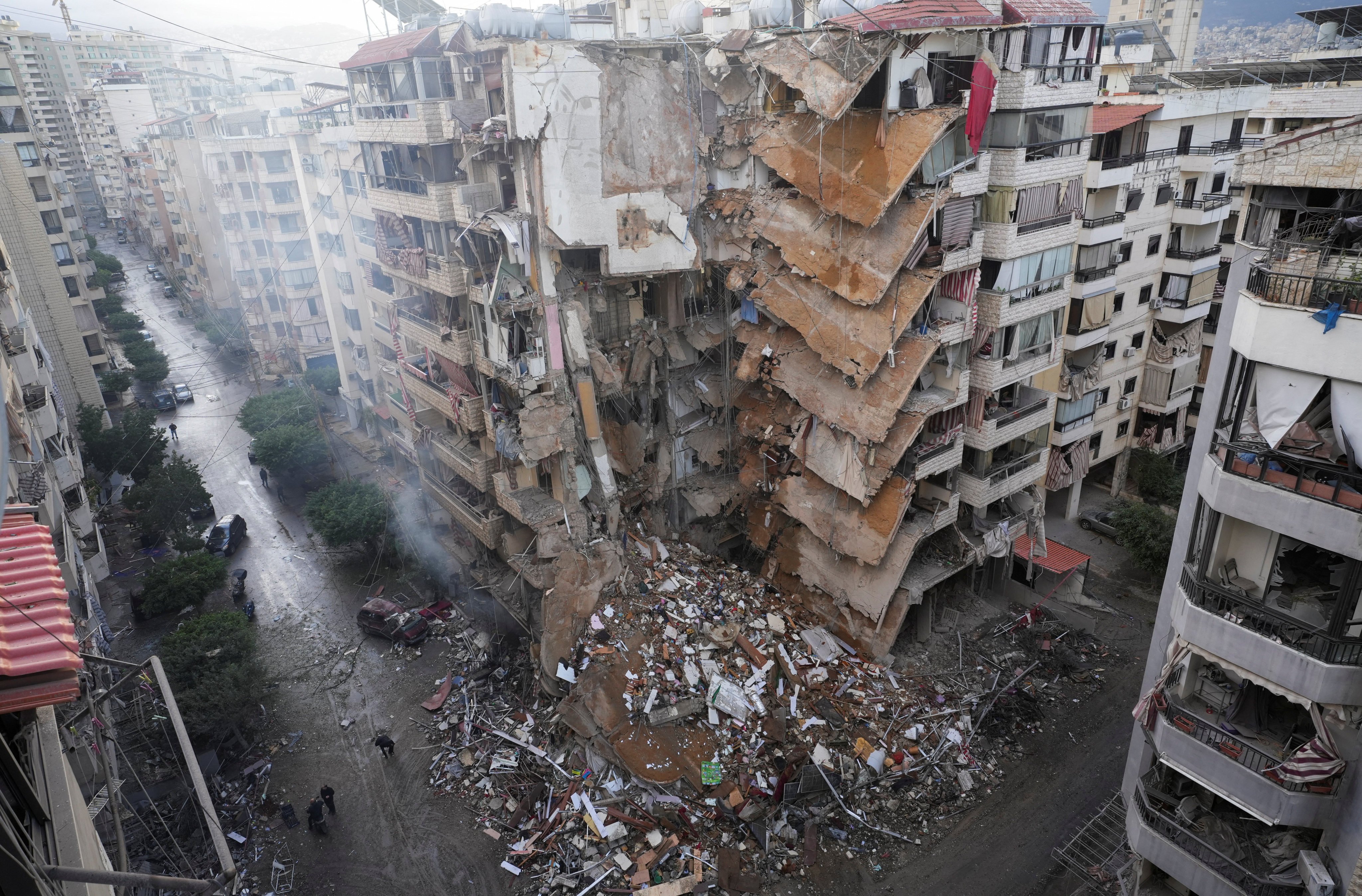 People walk past damaged buildings, in the aftermath of Israeli strikes on Beirut’s southern suburbs, in Lebanon on Monday. Photo: Reuters