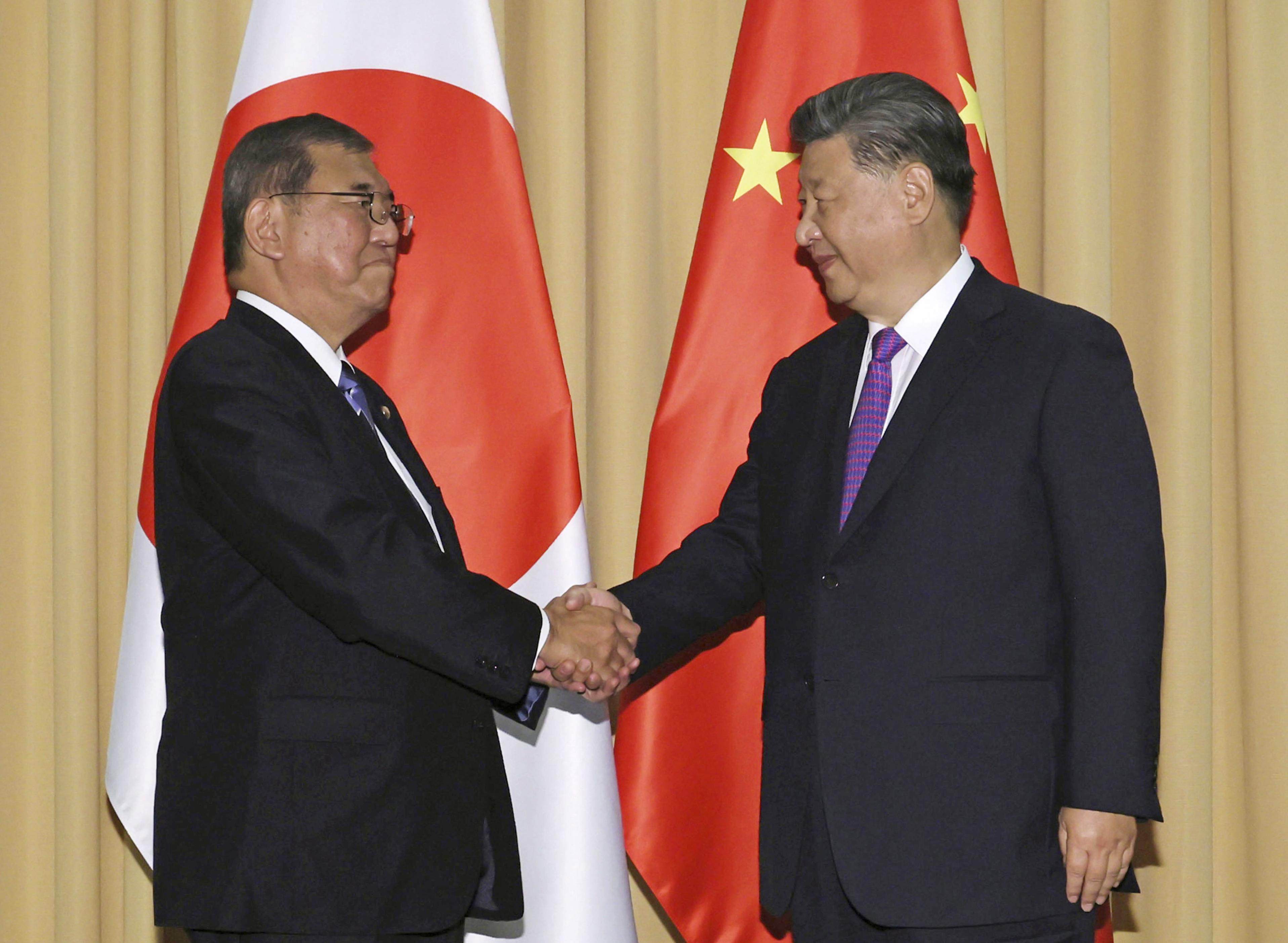 Japanese Prime Minister Shigeru Ishiba (left) and Chinese President Xi Jinping shake hands ahead of their talks in Lima on November 15. Photo: Kyodo