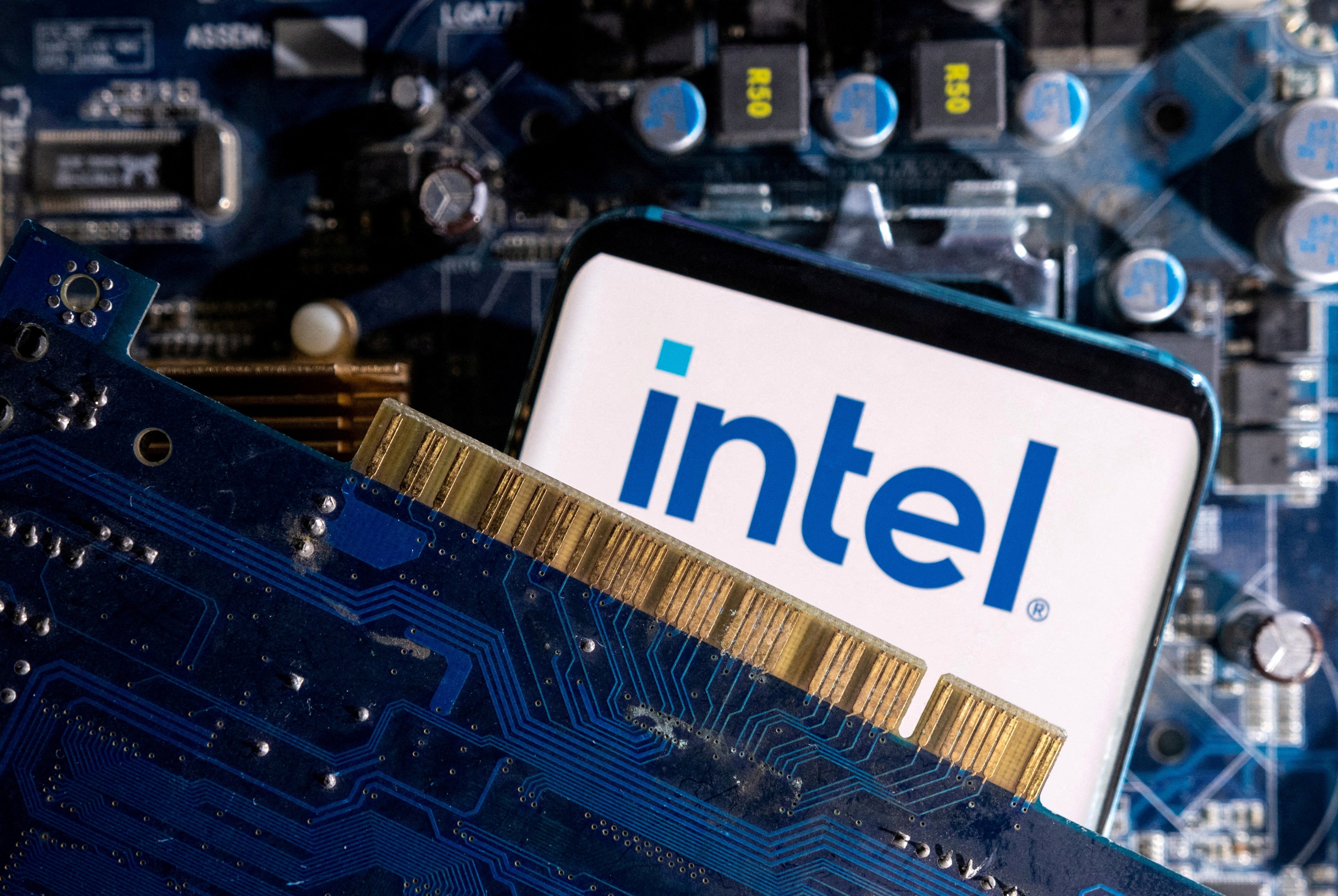 A smartphone with a displayed Intel logo is placed on a computer motherboard. Photo: Reuters