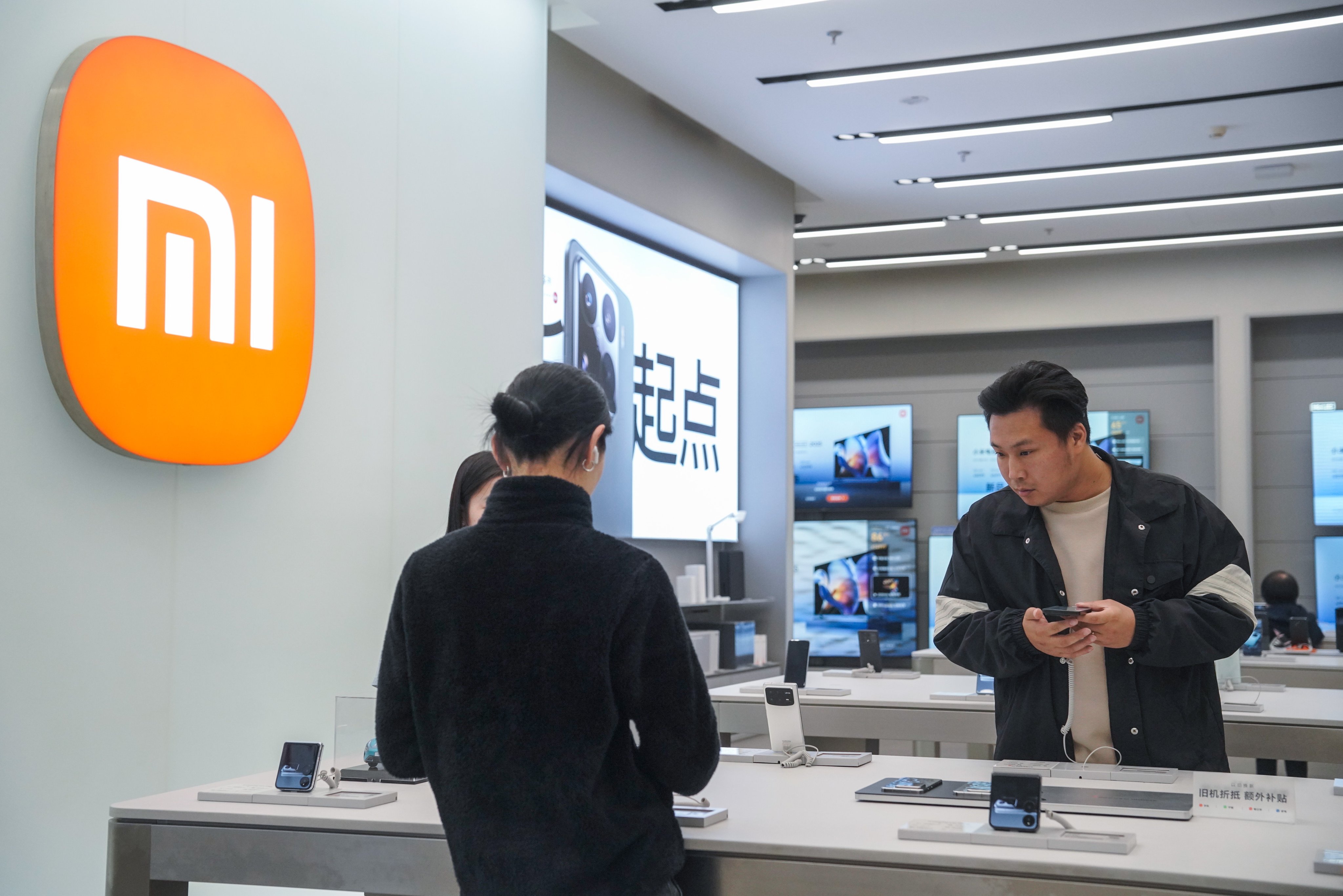 People check the latest Xiaomi 15 smartphones at a store in Beijing on October 30. Photo: EPA-EFE