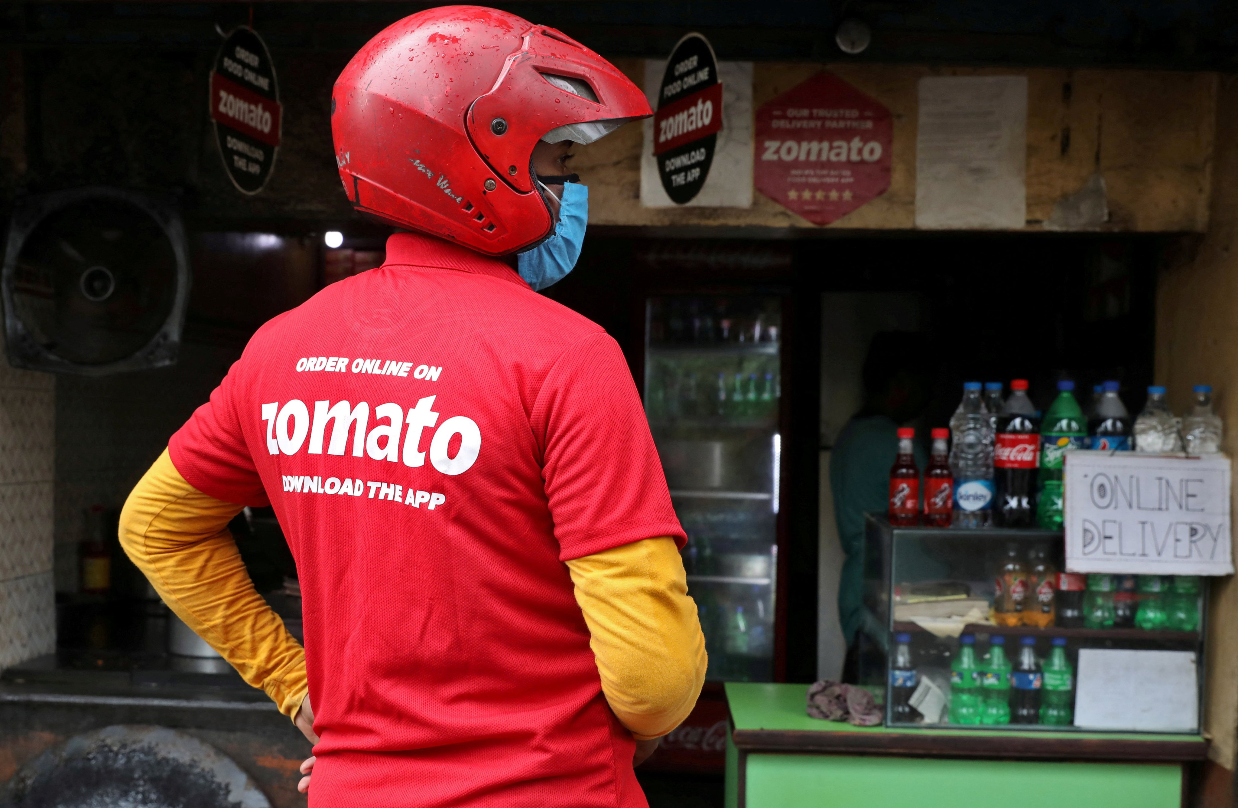 A delivery worker of Zomato, an Indian food-delivery startup, waits to collect an order in Kolkata. Photo: Reuters